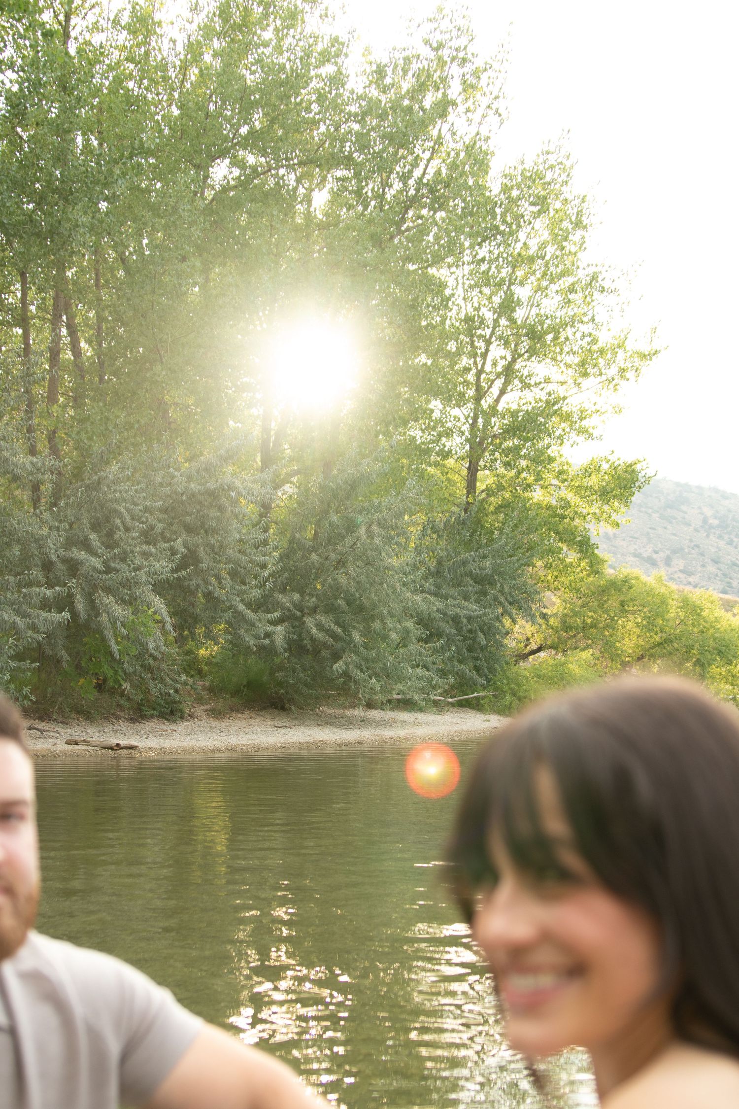A lakeside sunset photo with lens flare creating a dreamy atmosphere.