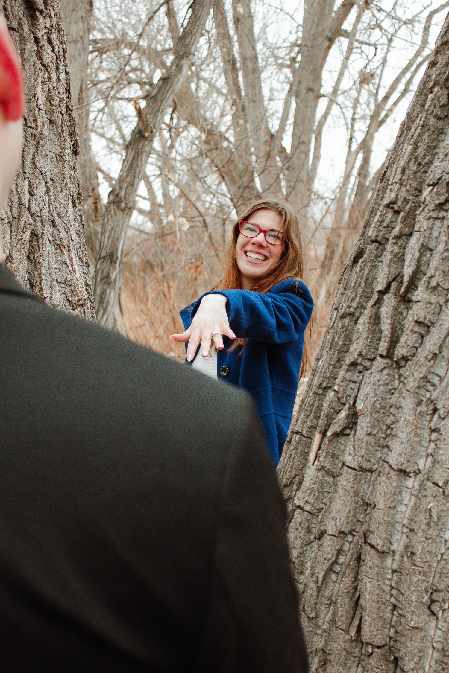 A joyful moment captured between two people playing among trees.
