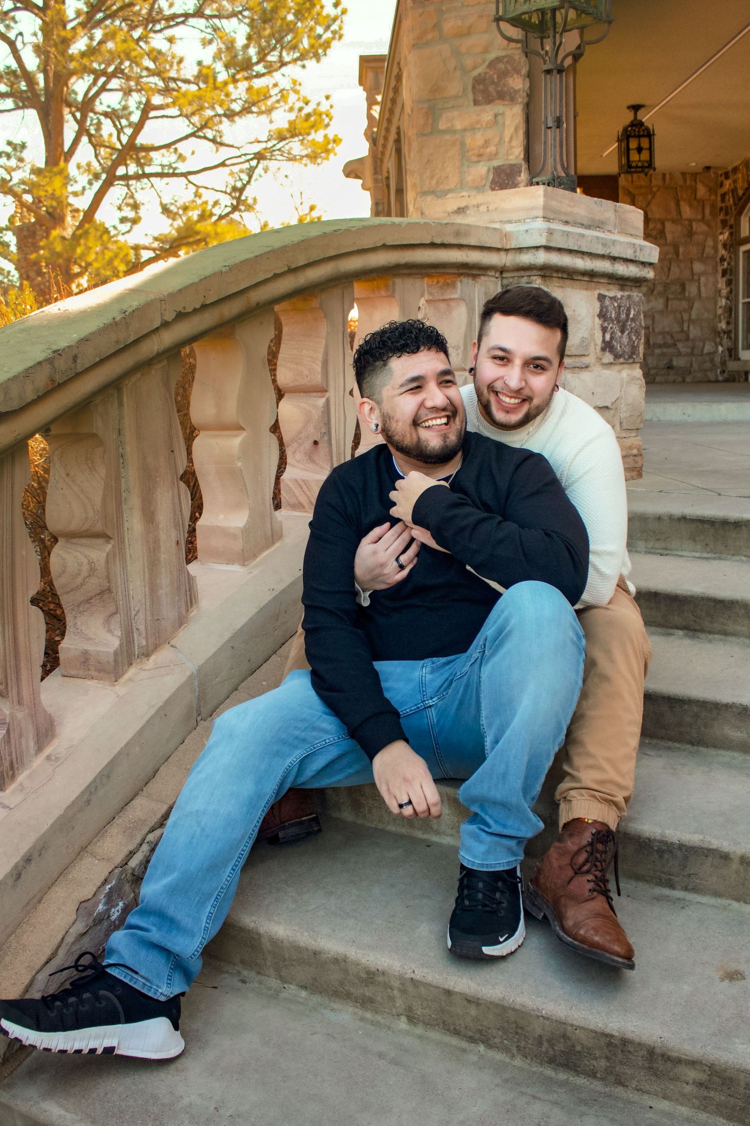 Playful interaction captured between two people on outdoor stone steps at sunset.