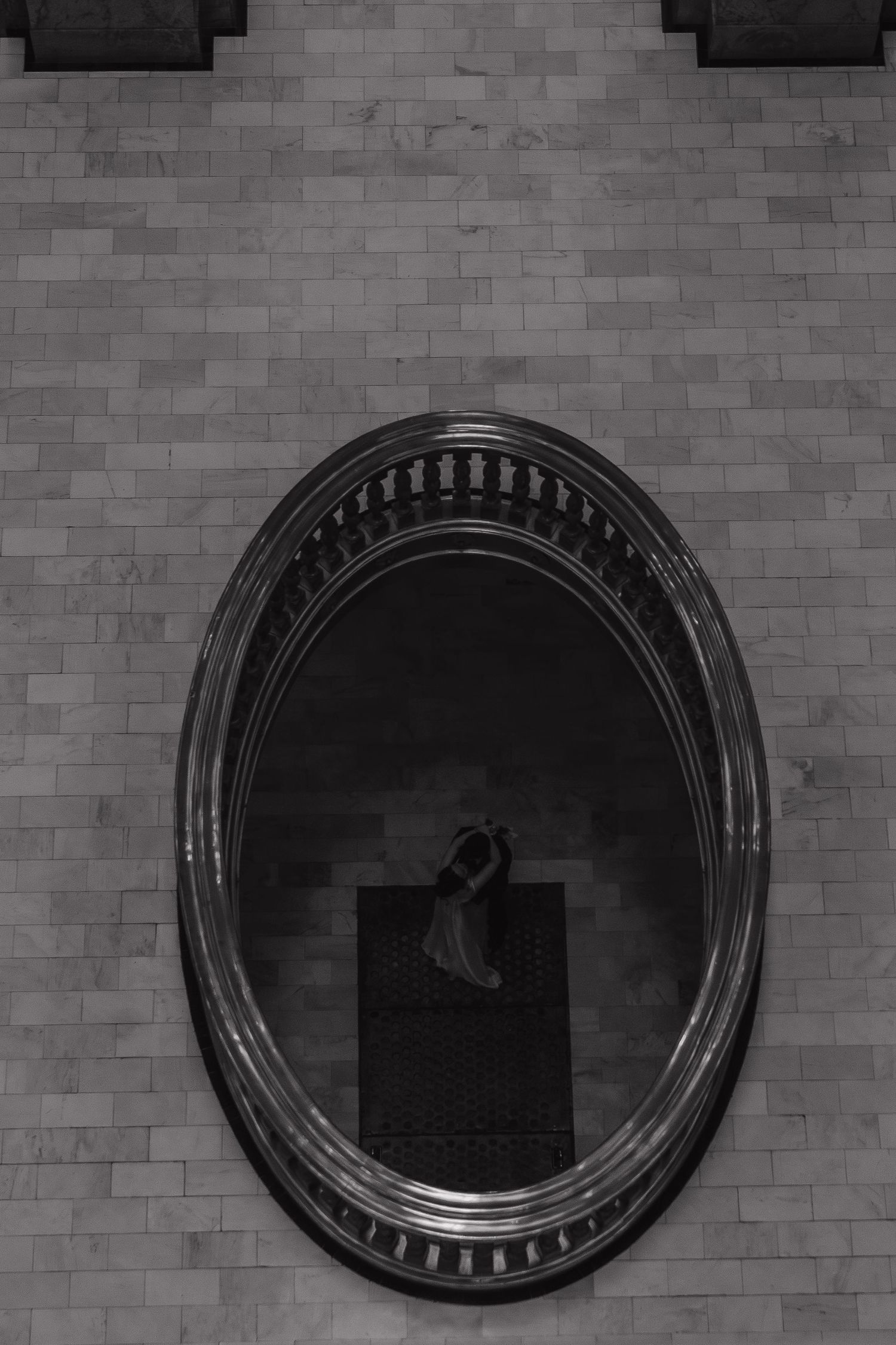 Black and white circular architectural details on a brick wall create a repeating geometric pattern.