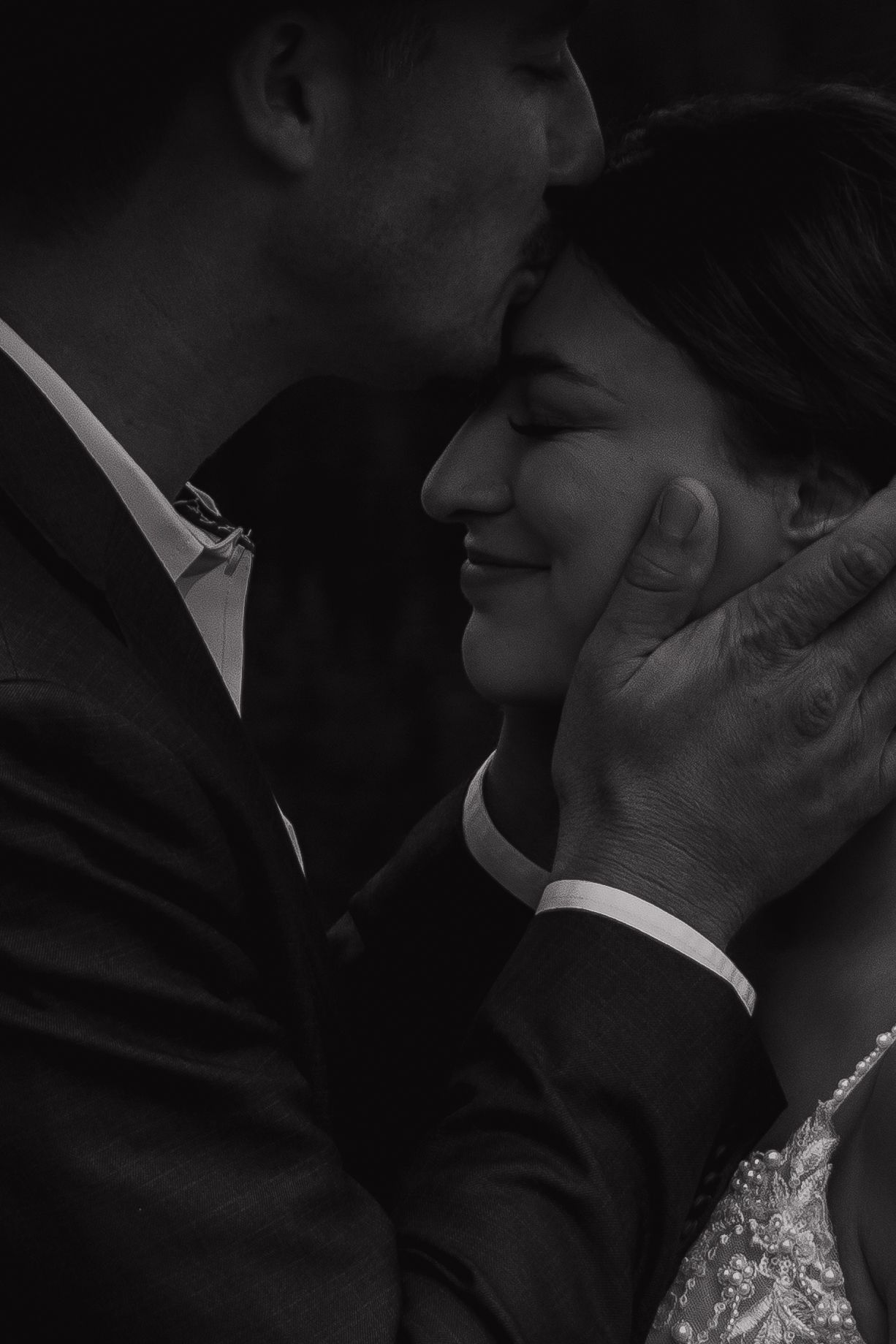An intimate black and white close-up of a tender moment between newlyweds.