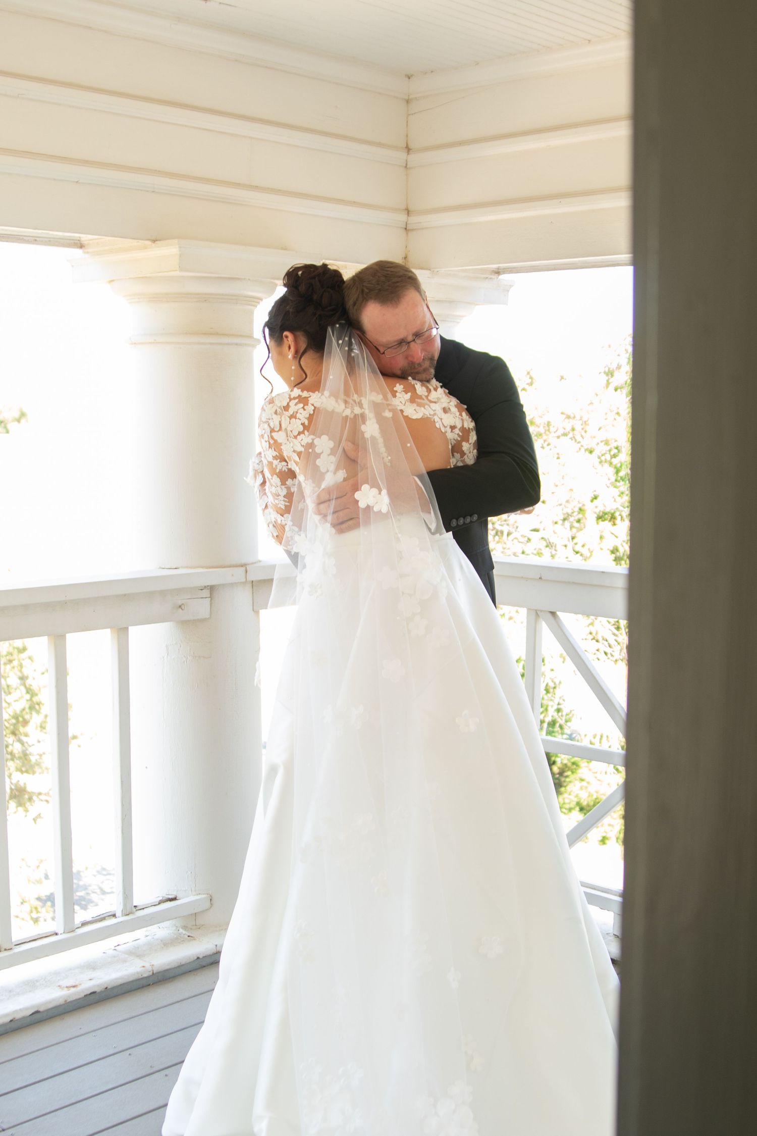 Wedding couple sharing intimate moments on outdoor porch.