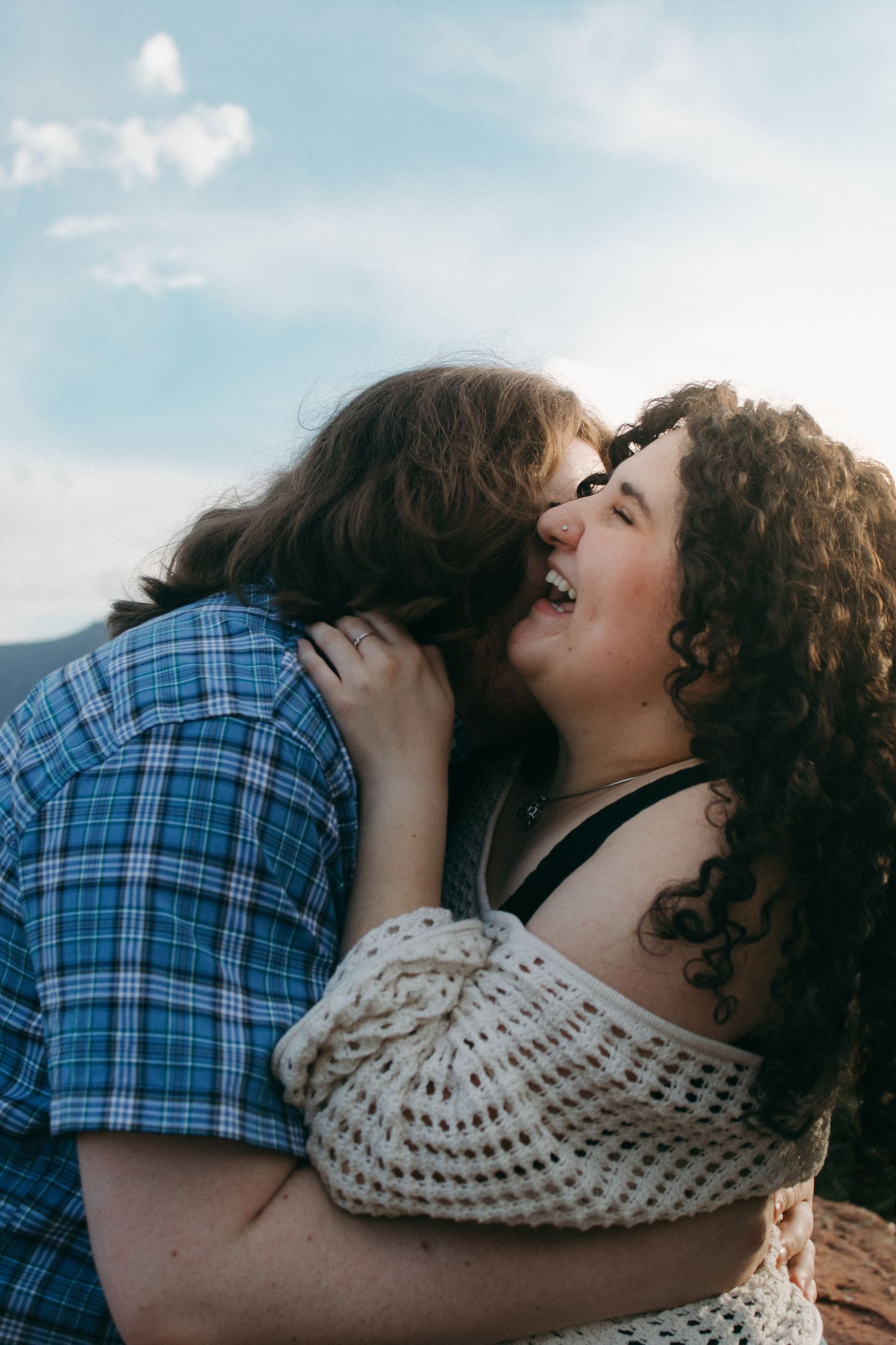 A tender moment between two people during a golden hour photoshoot in nature.
