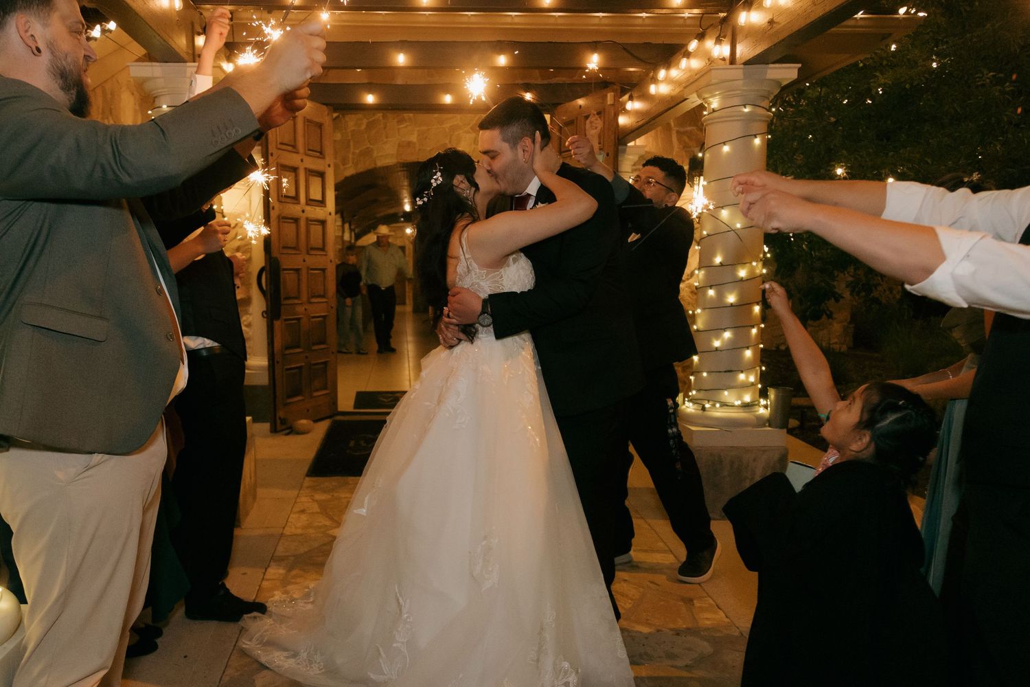 Bride and groom sharing a romantic embrace during a sparkler send-off exit at their evening wedding reception.