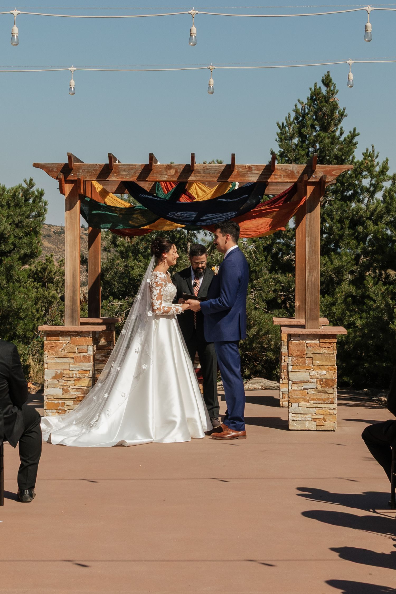 Wedding ceremony sequence showing couple exchanging vows under wooden pergola with stone pillars.
