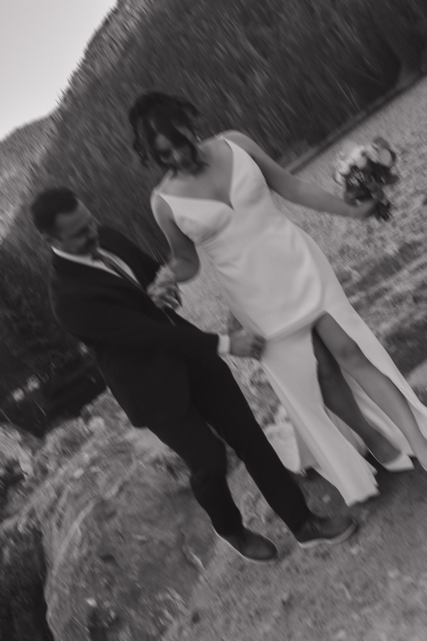 Black and white wedding photos captured on a rocky mountainside terrain.