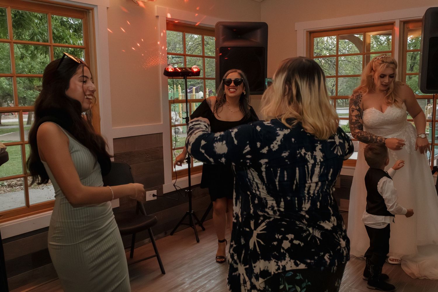 Wedding celebration in rustic venue with string lights and wooden trim.