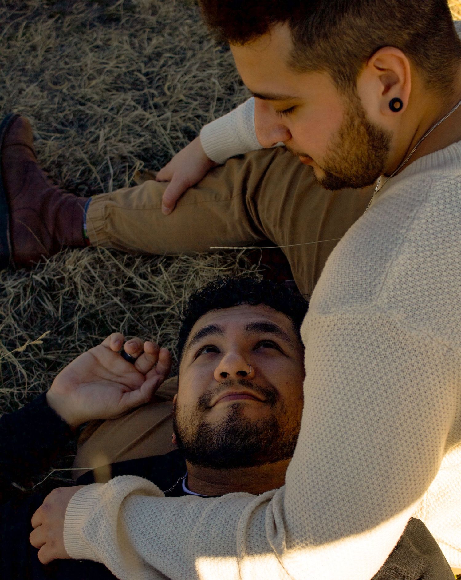 Close up of two people sharing an affectionate moment while resting outdoors.
