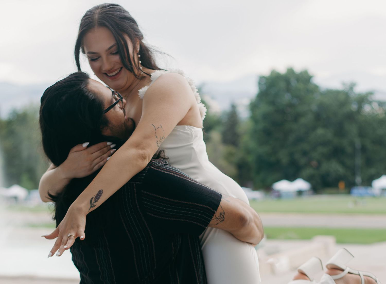 A series of candid romantic moments captured between a couple in white and black attire outdoors.
