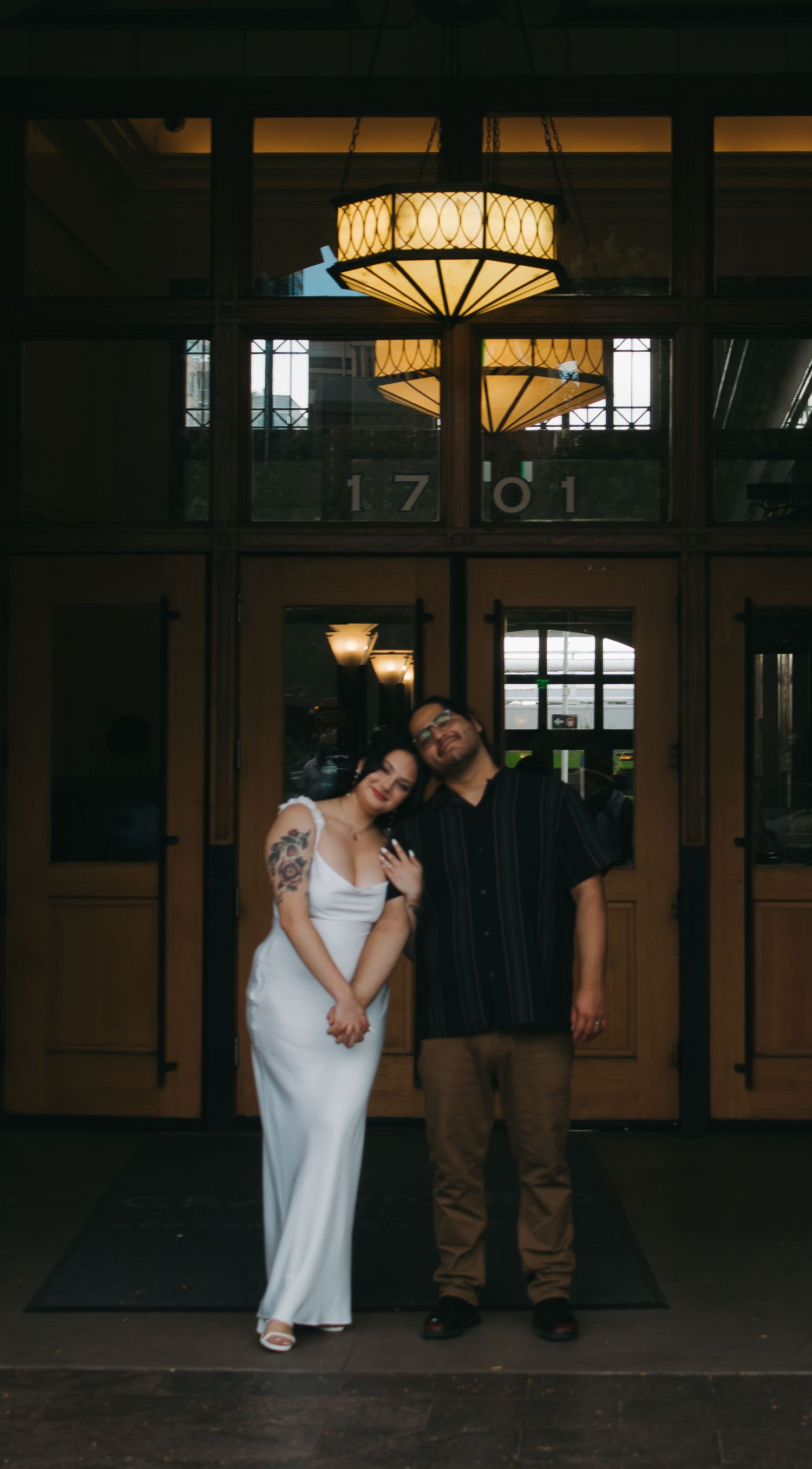 A romantic series of moody photos showing a couple in formal attire embracing in a dimly lit vintage space.