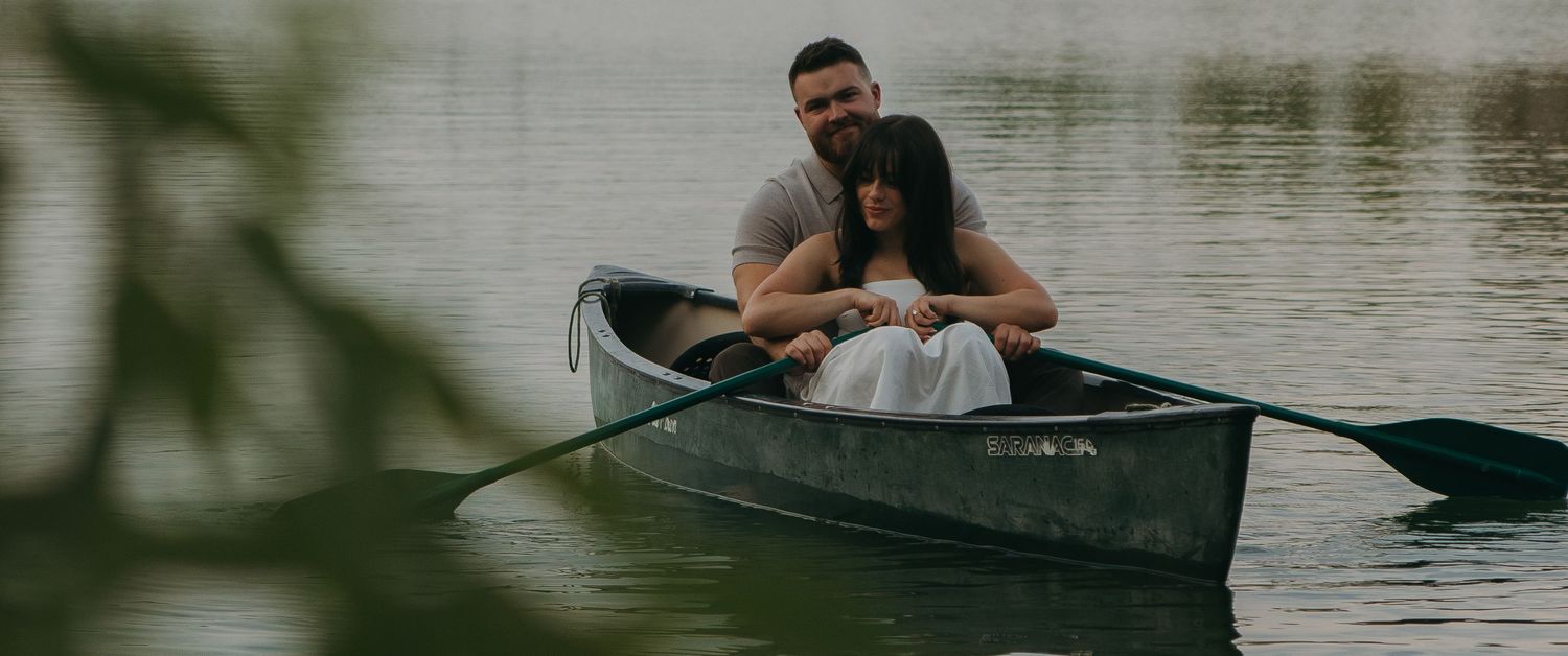 A peaceful lakeside moment captured in a canoe against a backdrop of mountains.