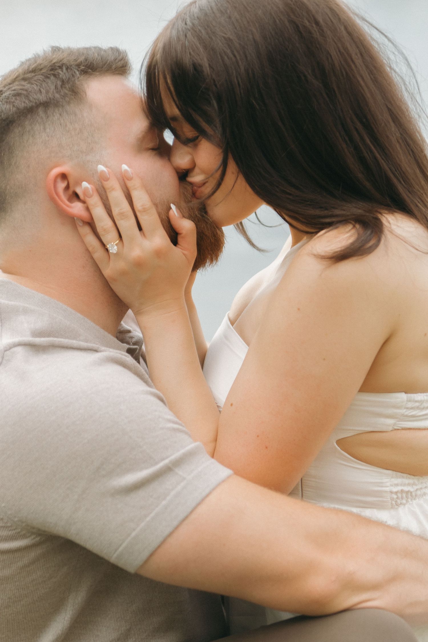 Intimate close-up moment captured against soft white background.