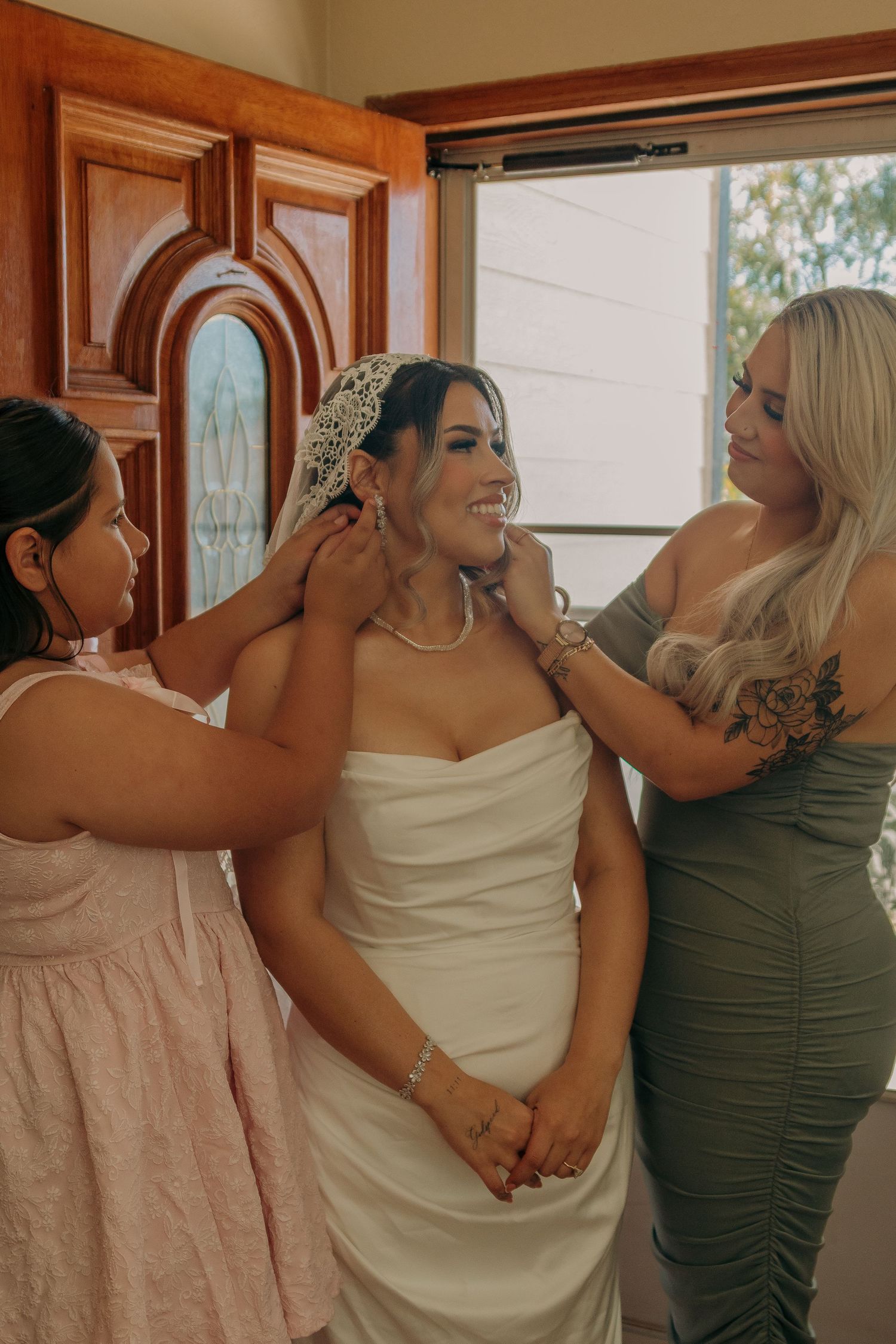 Wedding party members share candid moments while getting ready in elegant formal attire.