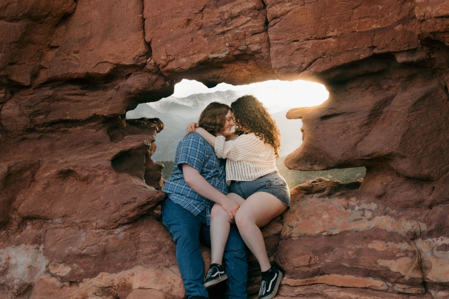 Romantic desert photoshoot with natural rock arch framing the scene.
