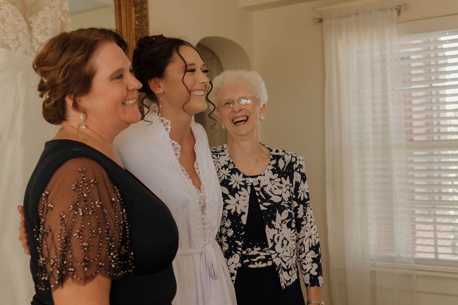 A wedding party sharing a joyful moment indoors with elegant decor.