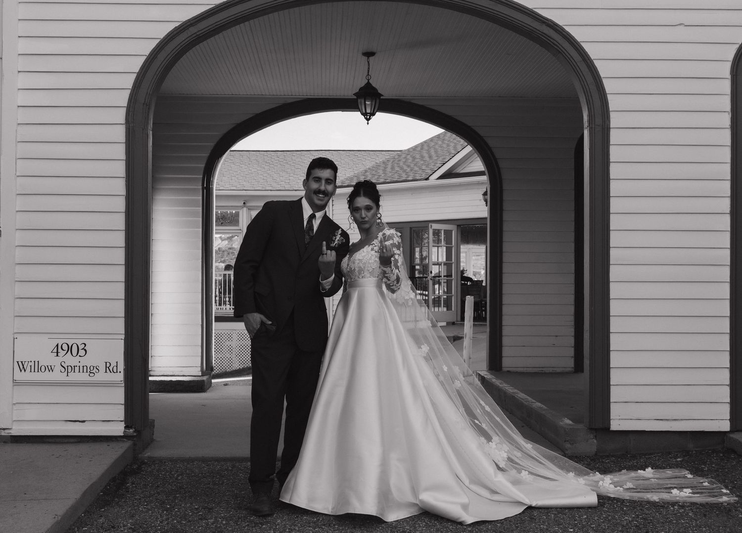 Classic black and white wedding portrait under an elegant arched doorway.