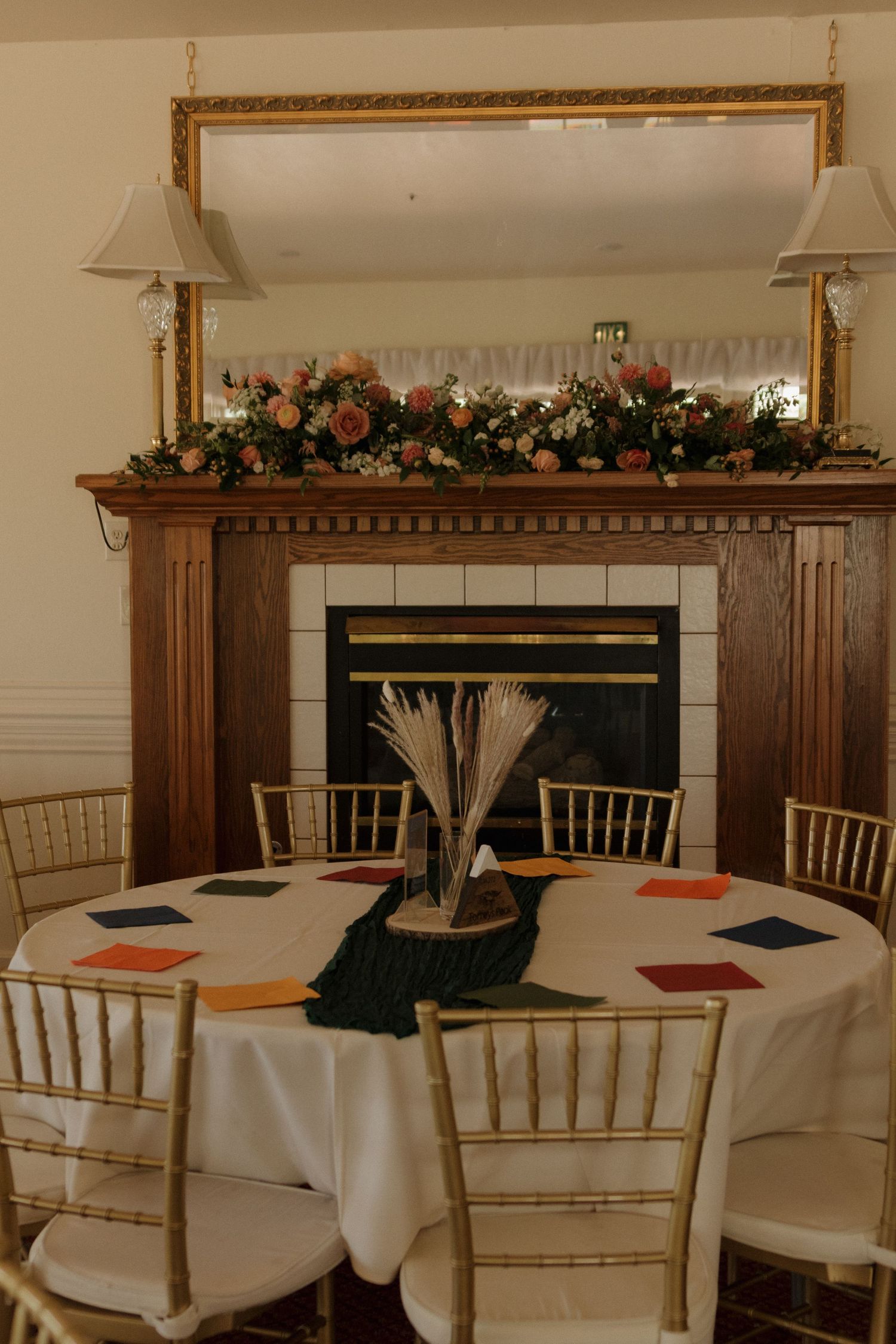 Elegant wedding reception tables adorned with white linens, Chiavari chairs, and floral centerpieces in a banquet hall.