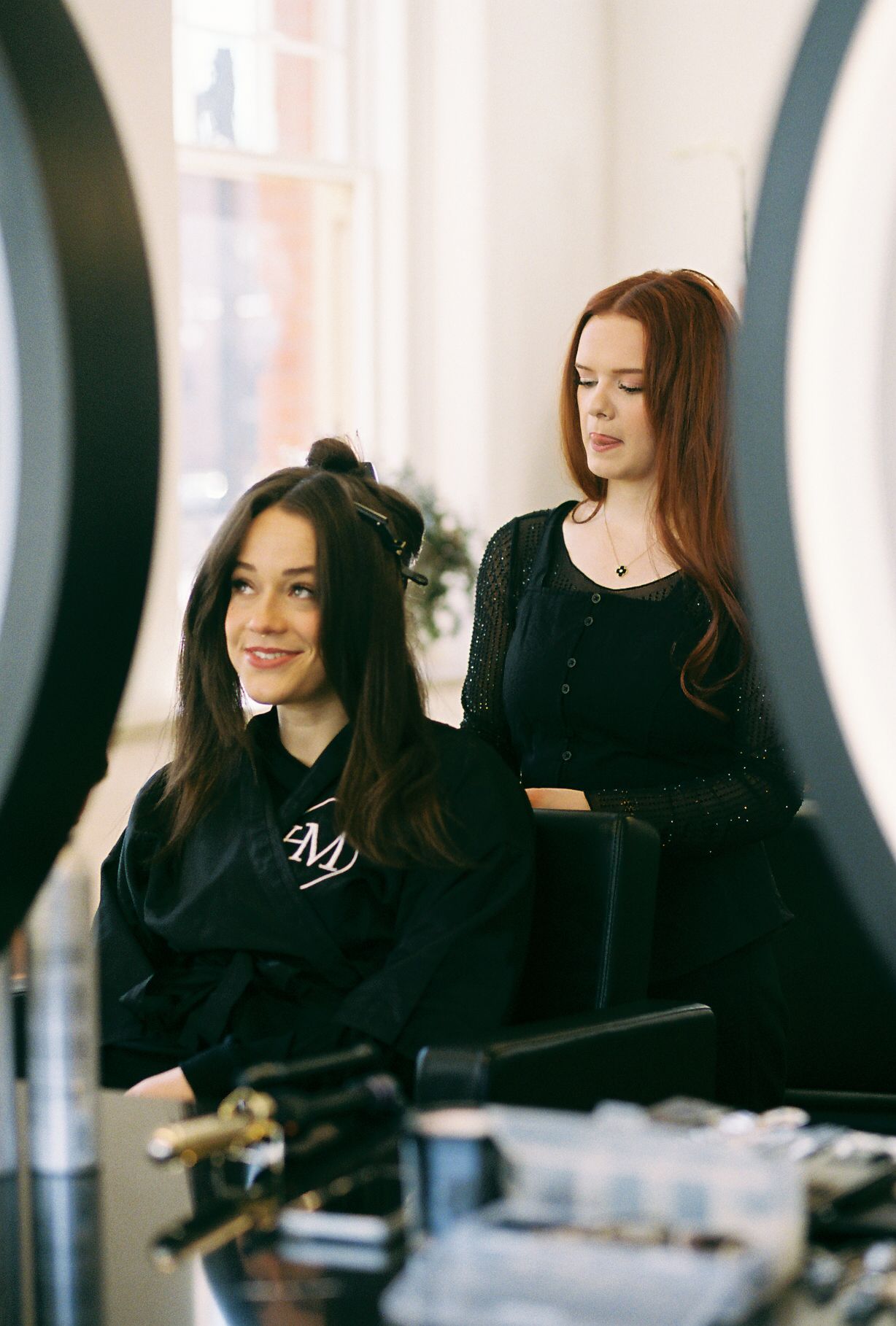 Four people dressed in black relax together during a casual photoshoot.