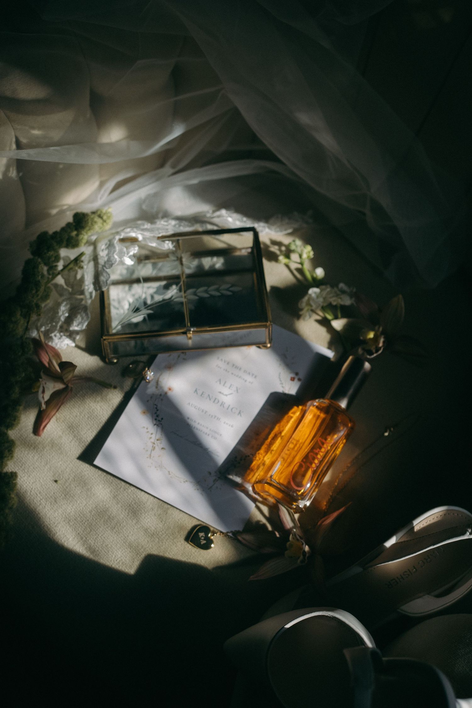 Wedding details and accessories artistically arranged with dramatic shadows and lighting.