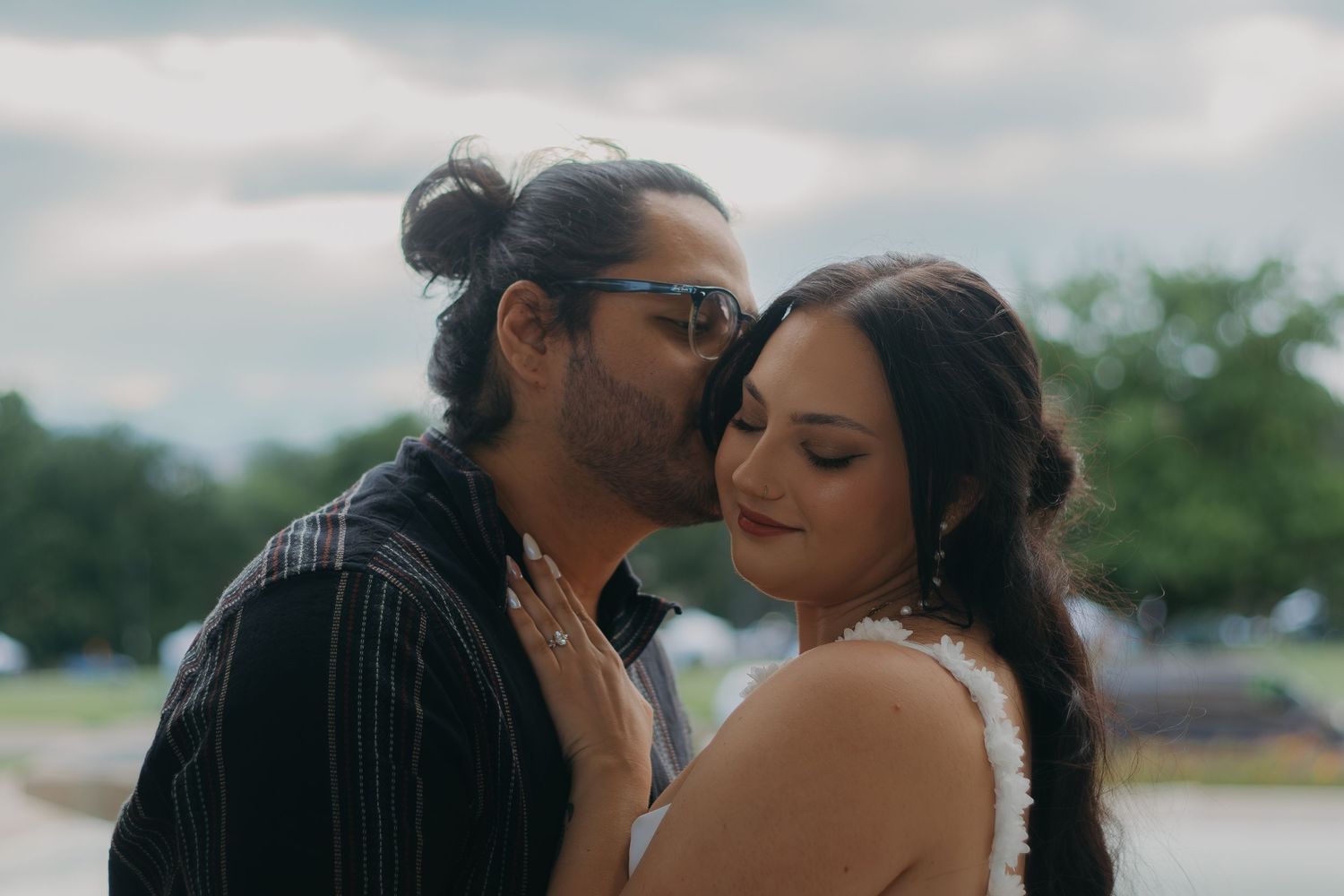 A romantic couple shares intimate moments outdoors, embracing and kissing in a series of candid shots.