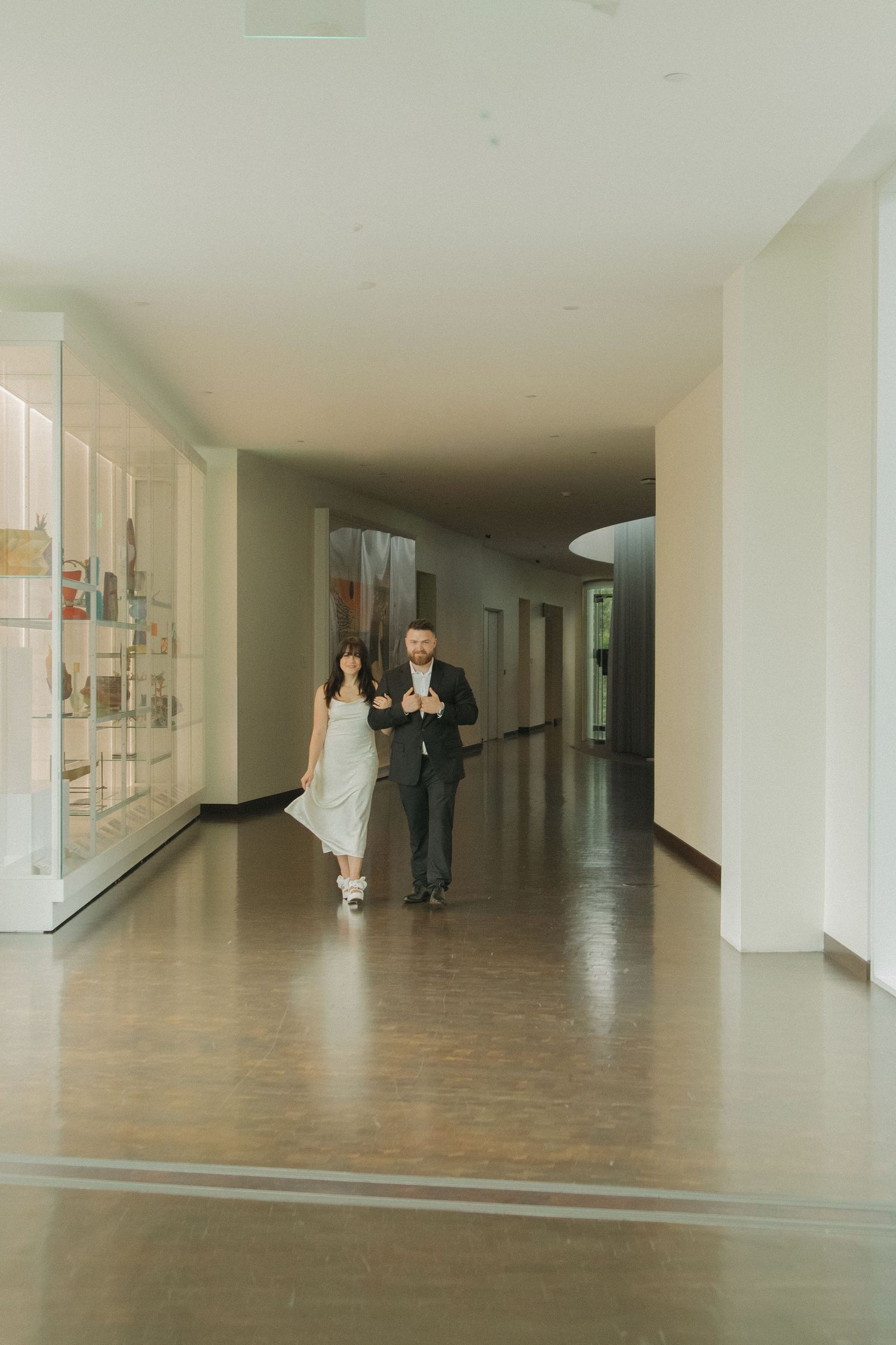 Long empty hallway with wooden floors and white walls showing multiple perspectives in gallery-style layout.