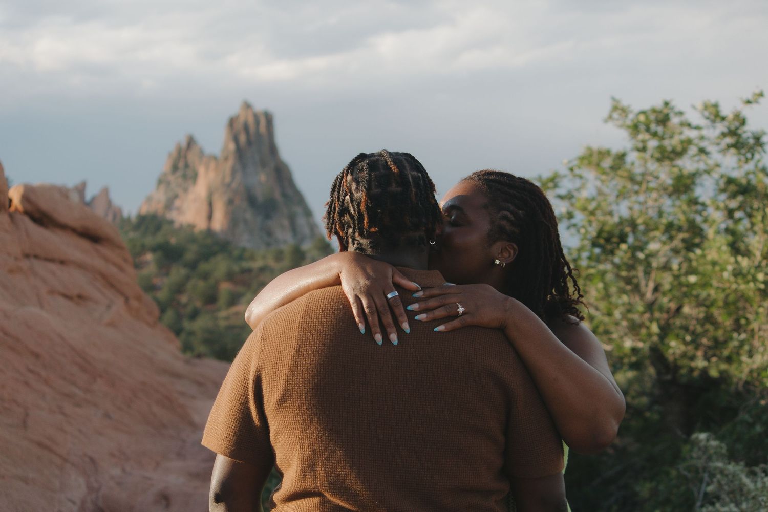 A romantic embrace captured against the dramatic rock formations at Garden of the Gods.