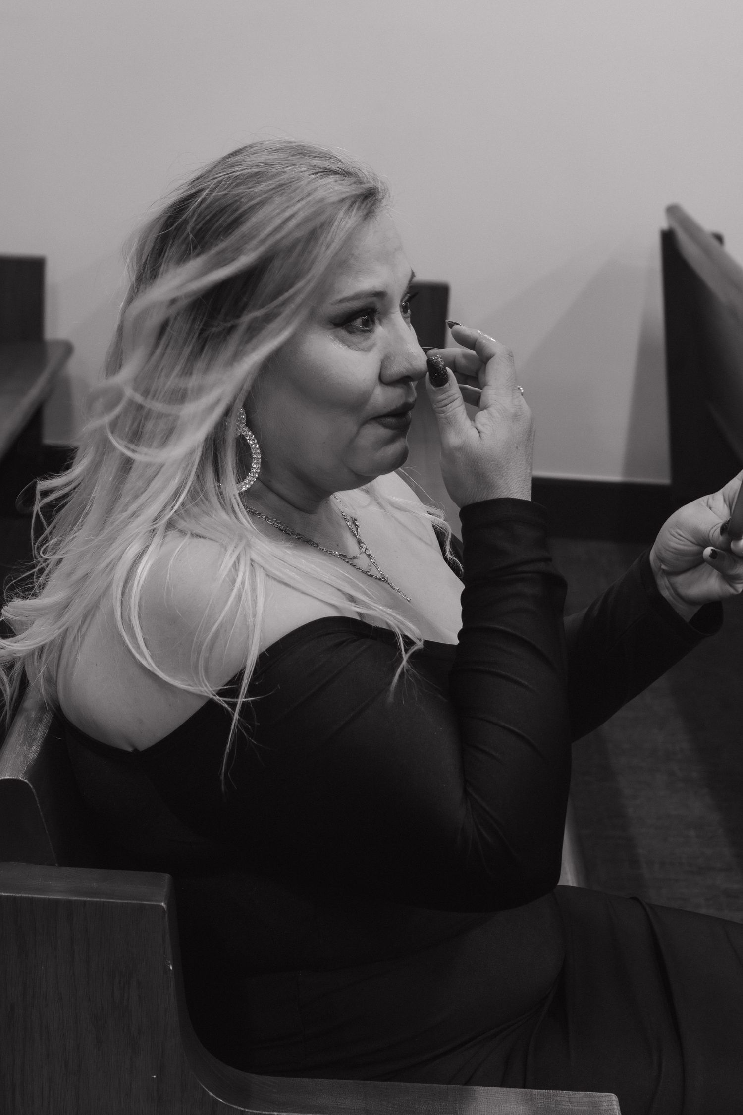 A series of black and white photos showing a person in a dark top making expressive gestures while seated.