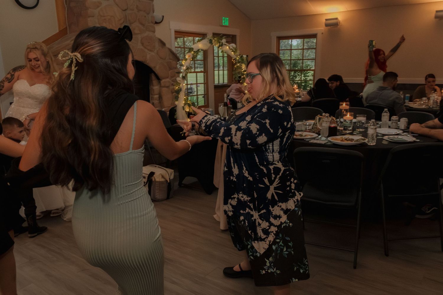 Wedding reception dance party with guests enjoying themselves in indoor venue.