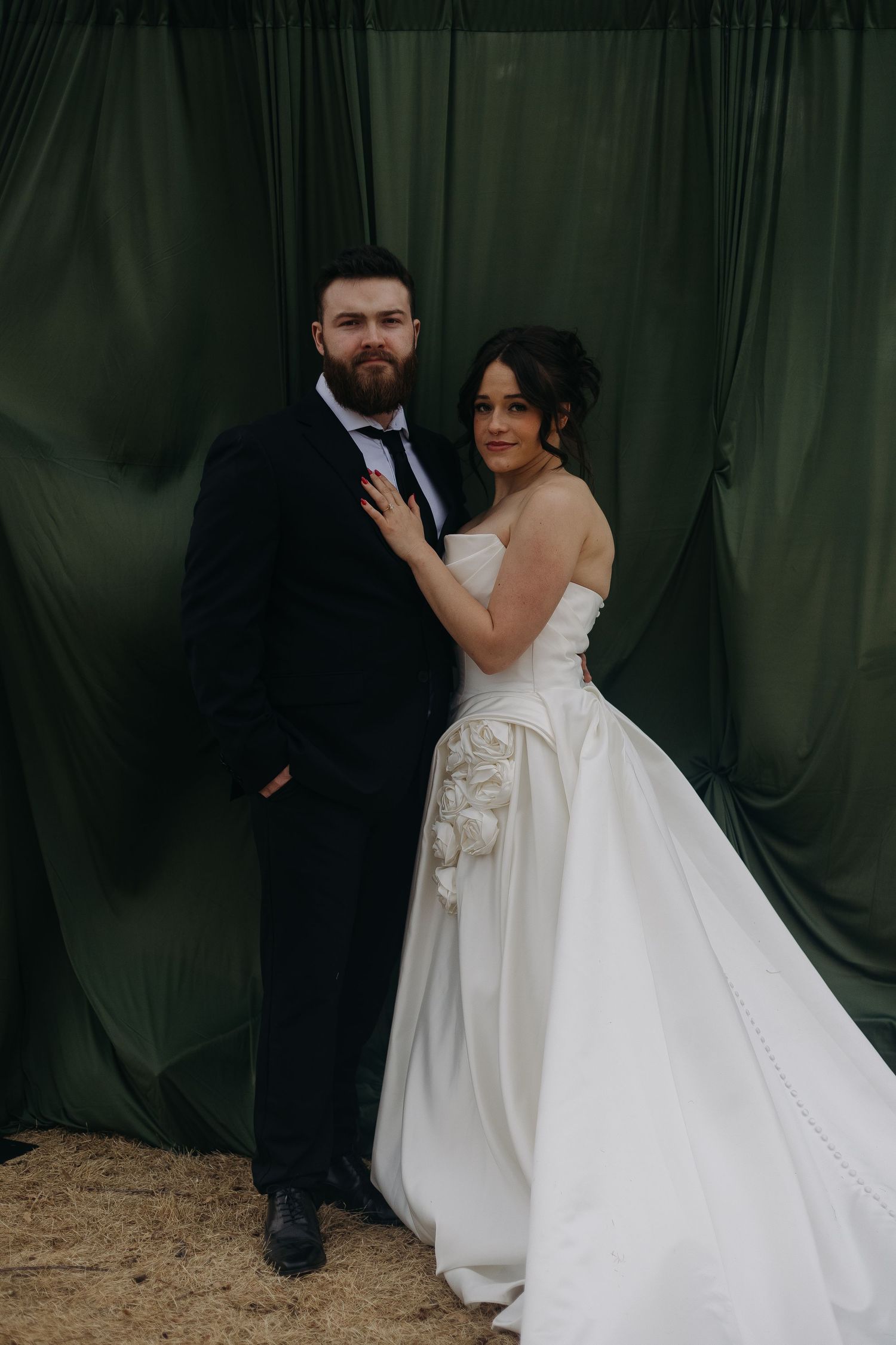 Wedding couple poses against dark green curtain backdrop in sequence of intimate moments.