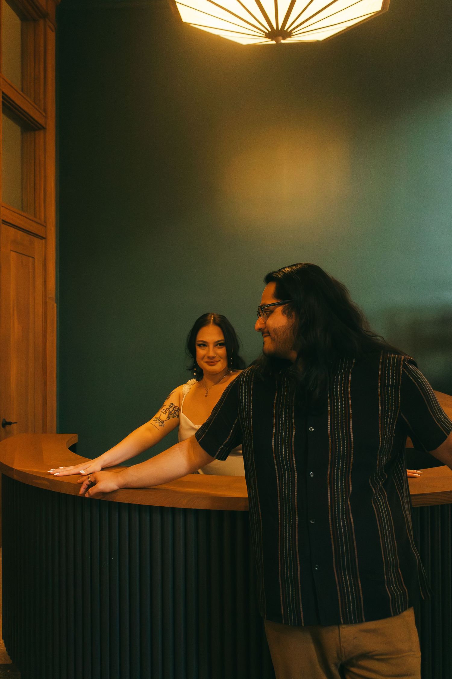 Four moody film photos show people seated at a dimly lit restaurant counter beneath retro ceiling lights.