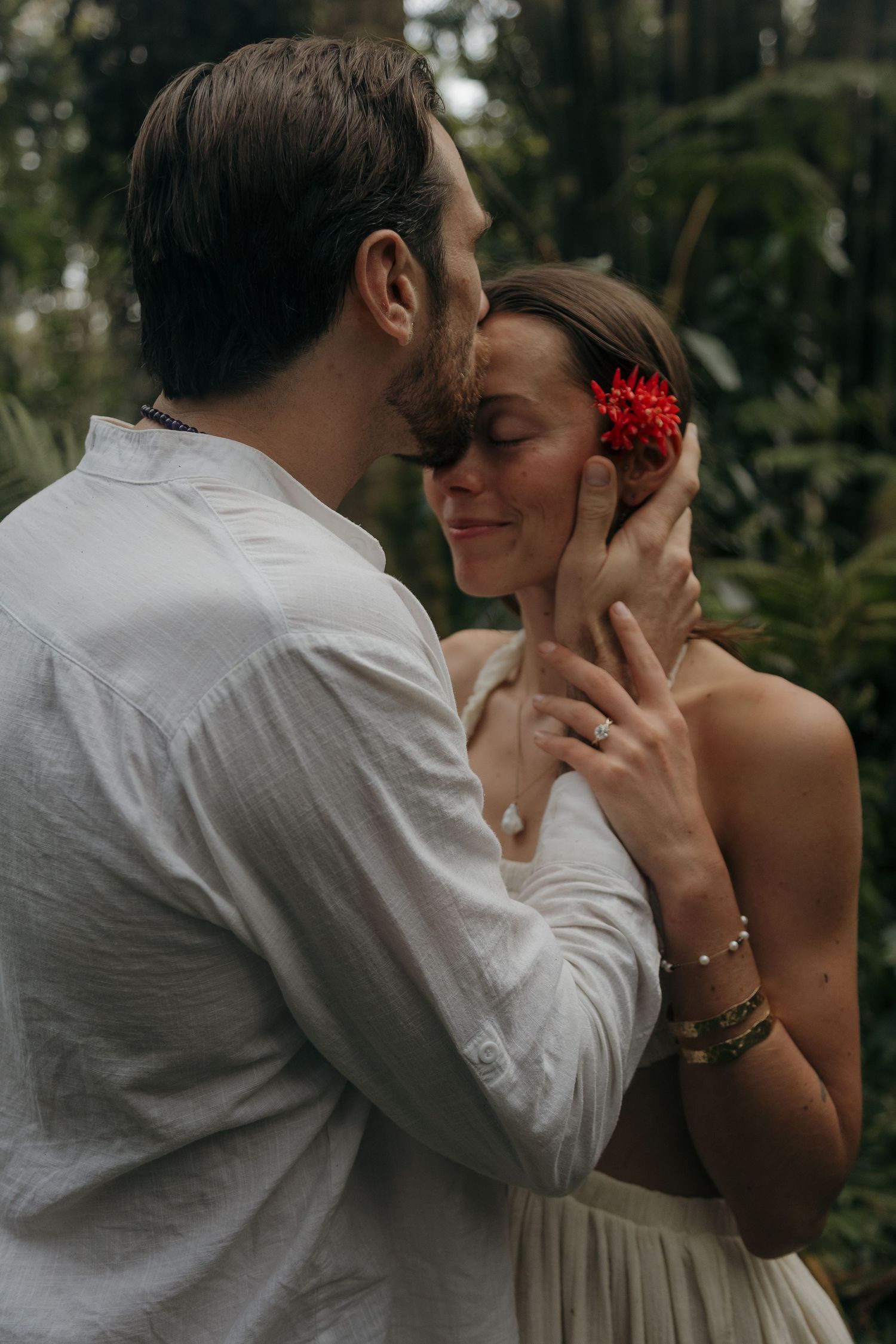 A romantic sequence of intimate moments between a couple in natural outdoor lighting with red floral accents.
