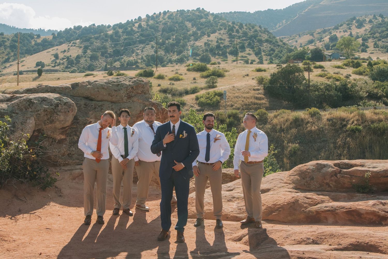 Group photo of wedding party members on a rocky mountain overlook.