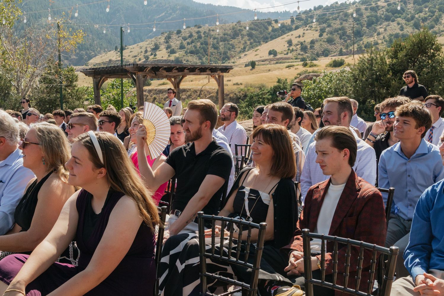 Wedding guests seated in rows with beautiful mountain landscape views.