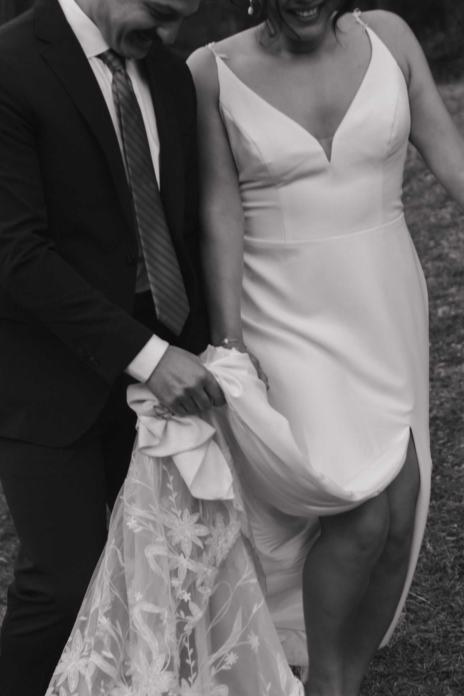 Intimate wedding moment captured showing details of a modern white bridal gown.