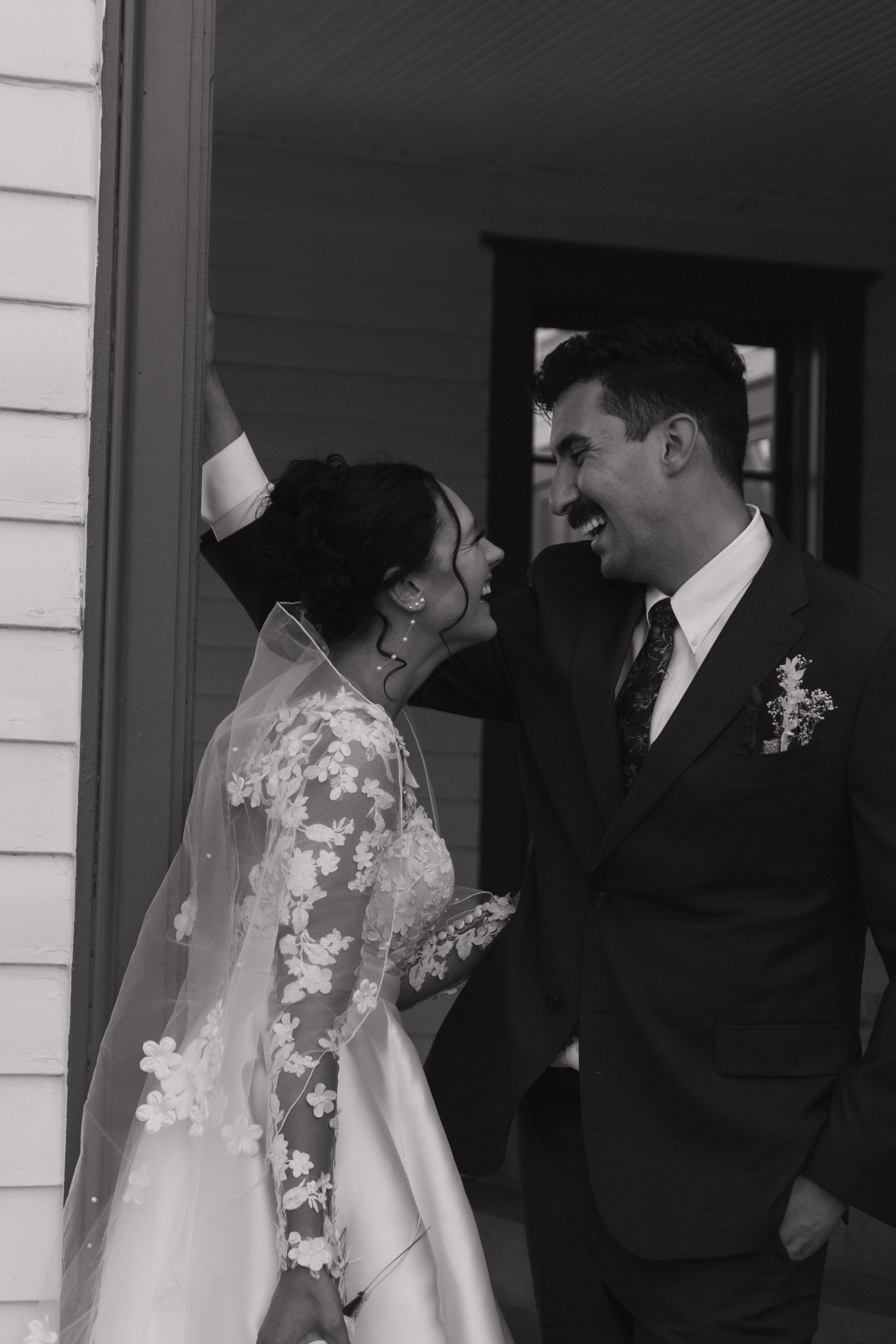 Black and white sequence of intimate wedding couple moments outside white building.