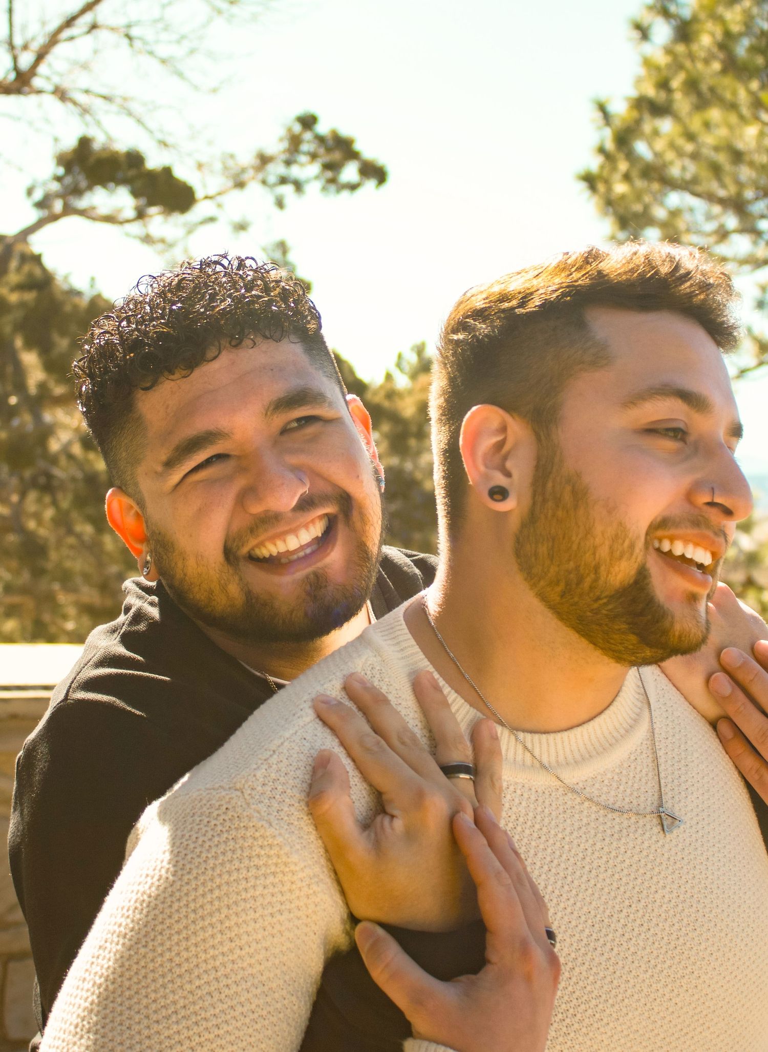 Two people share laughter and smiles in warm sunlight.