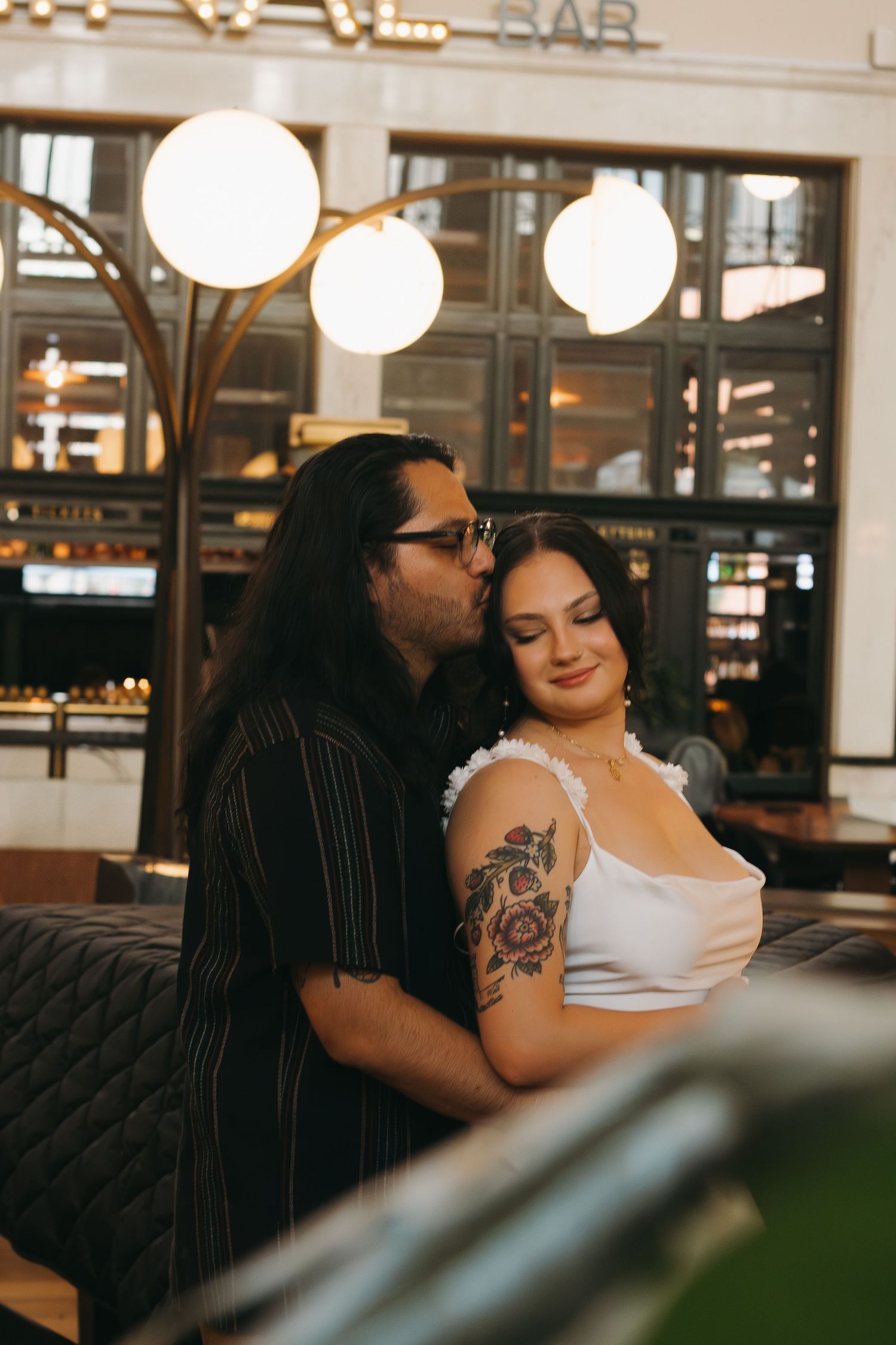 A tender moment shared under glowing pendant lights at Terminal Bar.