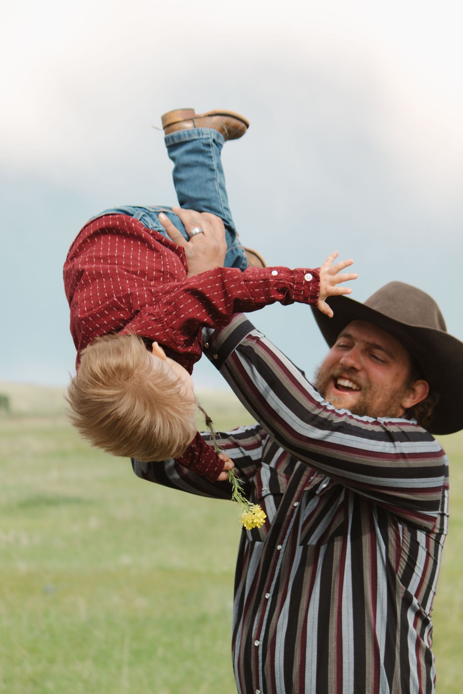 Joyful sequence showing a toddler being lifted into the air by someone wearing a cowboy hat and striped shirt.