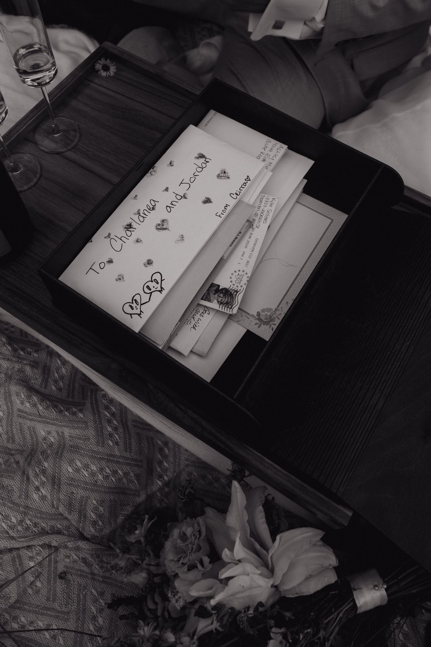 Black and white photo of handwritten wedding cards and letters displayed in a decorative box.
