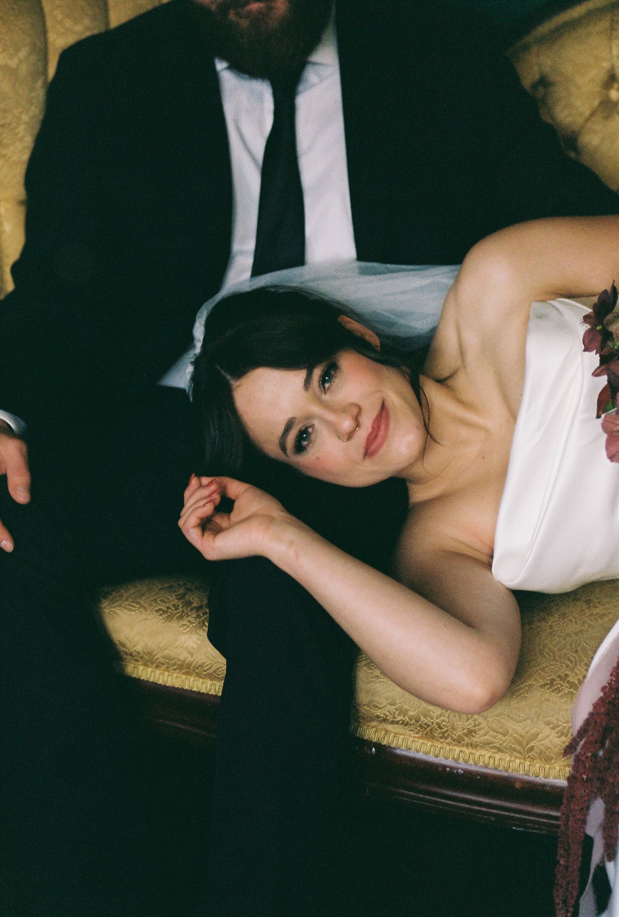 Elegant bridal portrait on vintage furniture with soft lighting and classic styling.