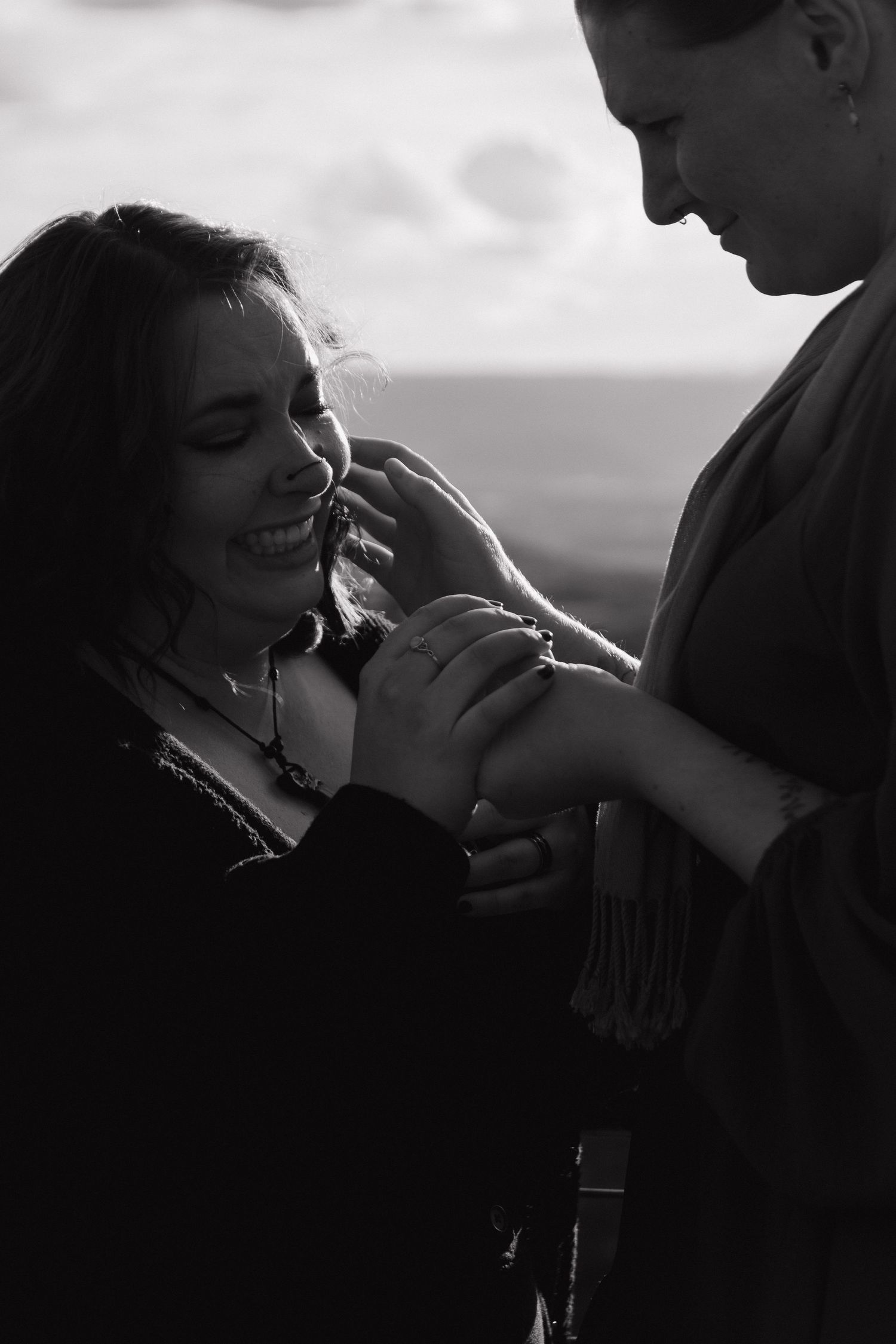 A romantic black and white silhouette of a couple sharing an intimate moment outdoors at sunset.