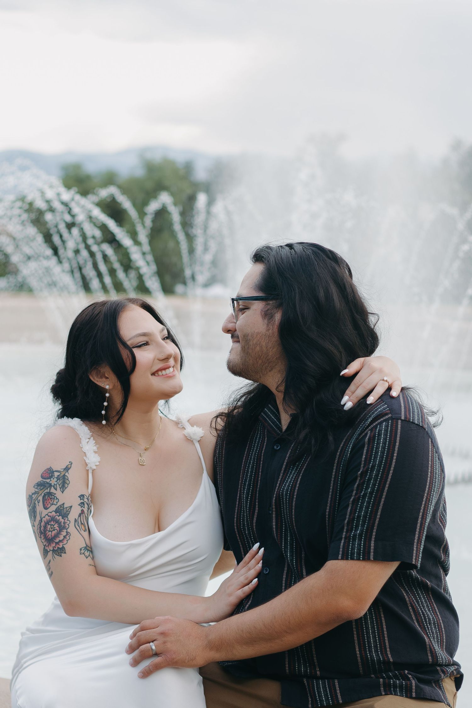 Romantic moment captured near fountain with couple in wedding attire.