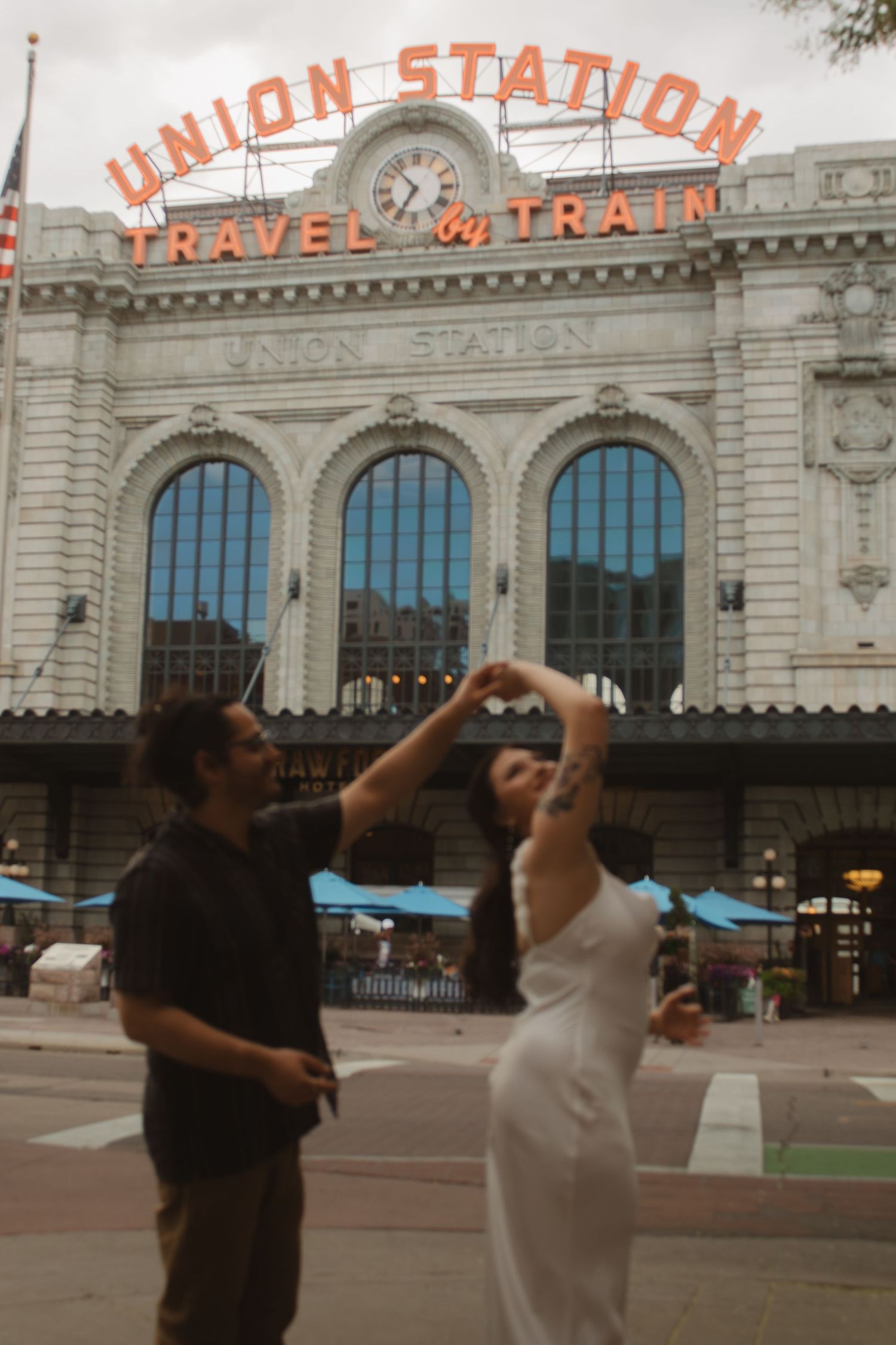 Dancing couple silhouetted against Union Station's iconic facade.
