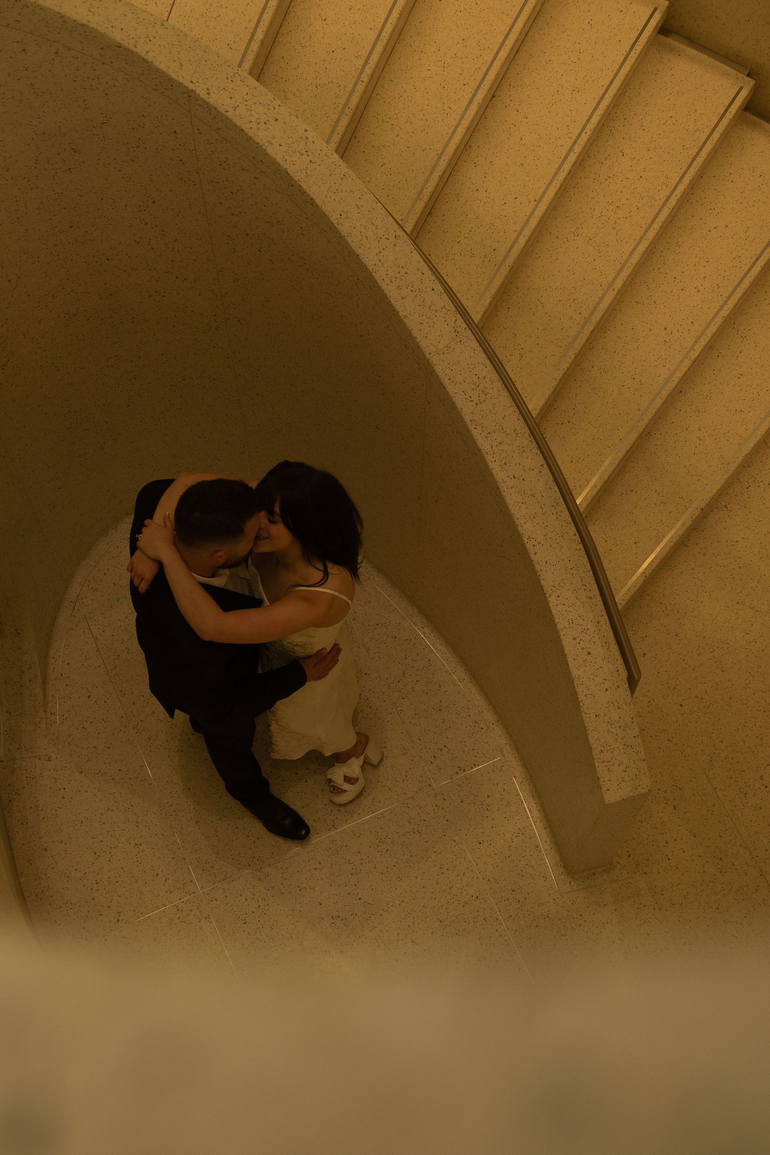 Series of sepia-toned photos showing a couple dancing in a curved architectural space.