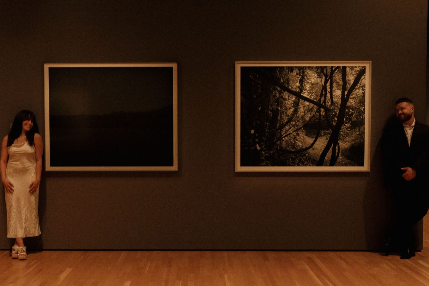 Dark gallery wall displaying black and white photographs in frames.