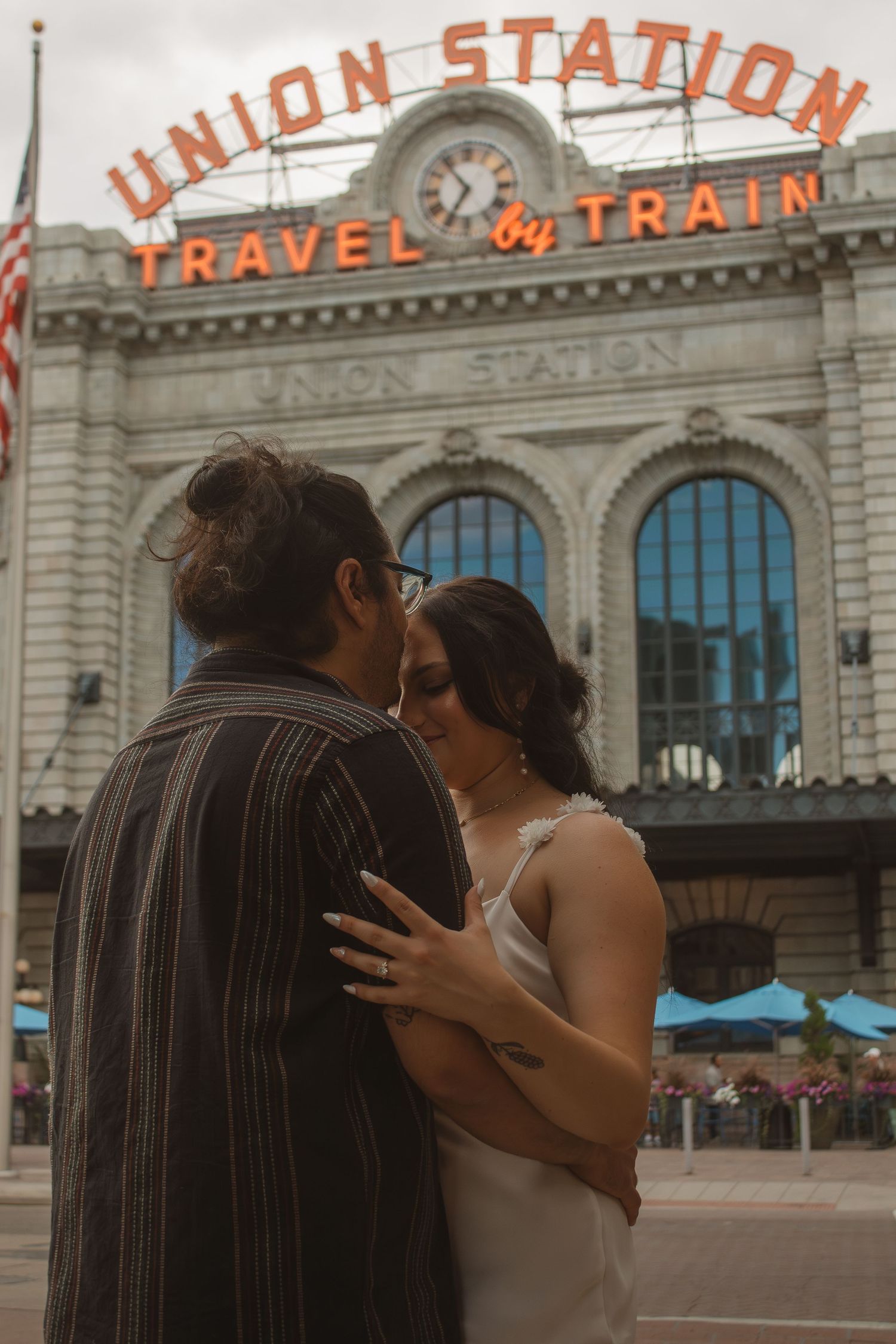 Romantic photoshoot outside historic Union Station building with vintage signage.
