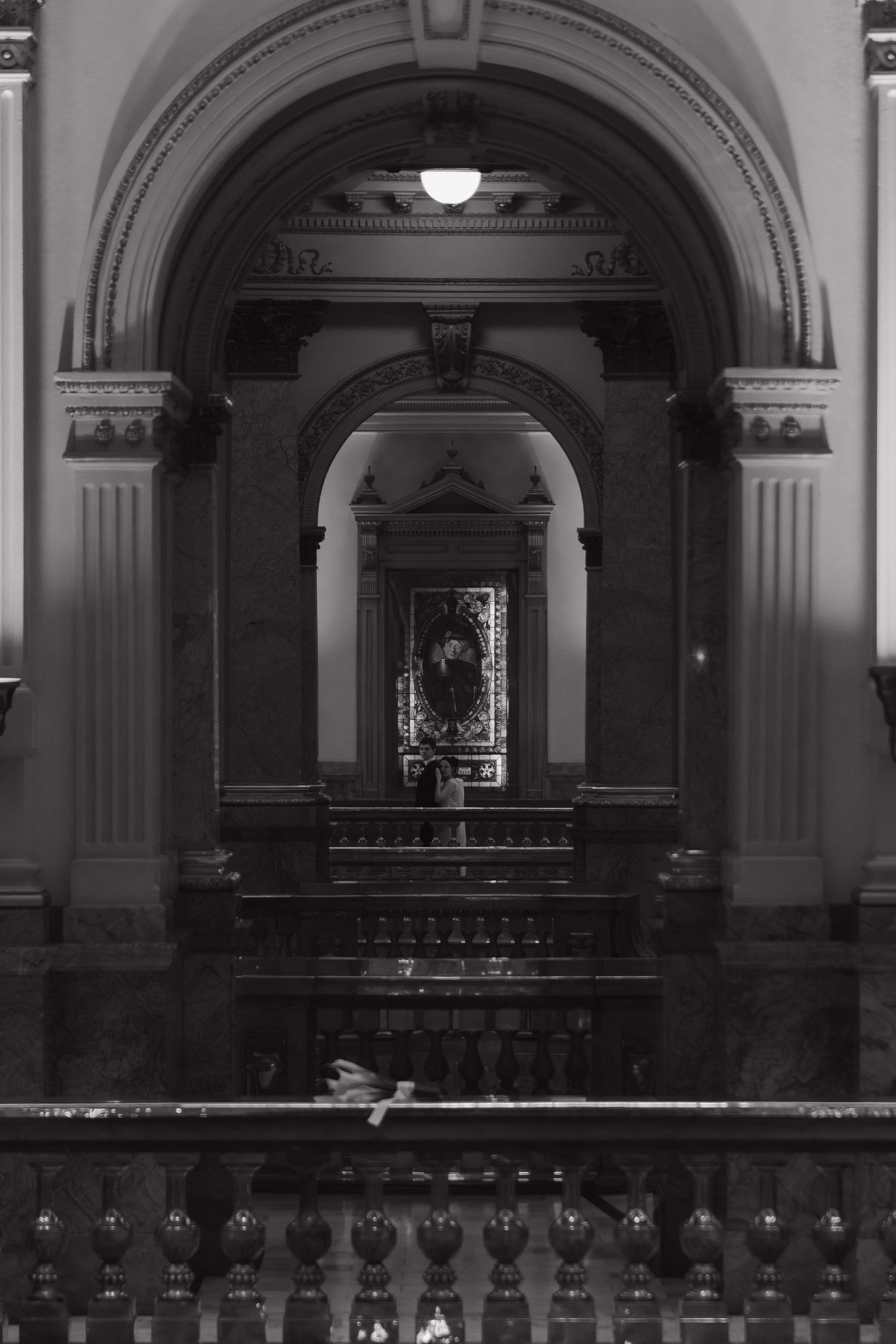 A black and white architectural photo showing arched hallways and classical interior details.