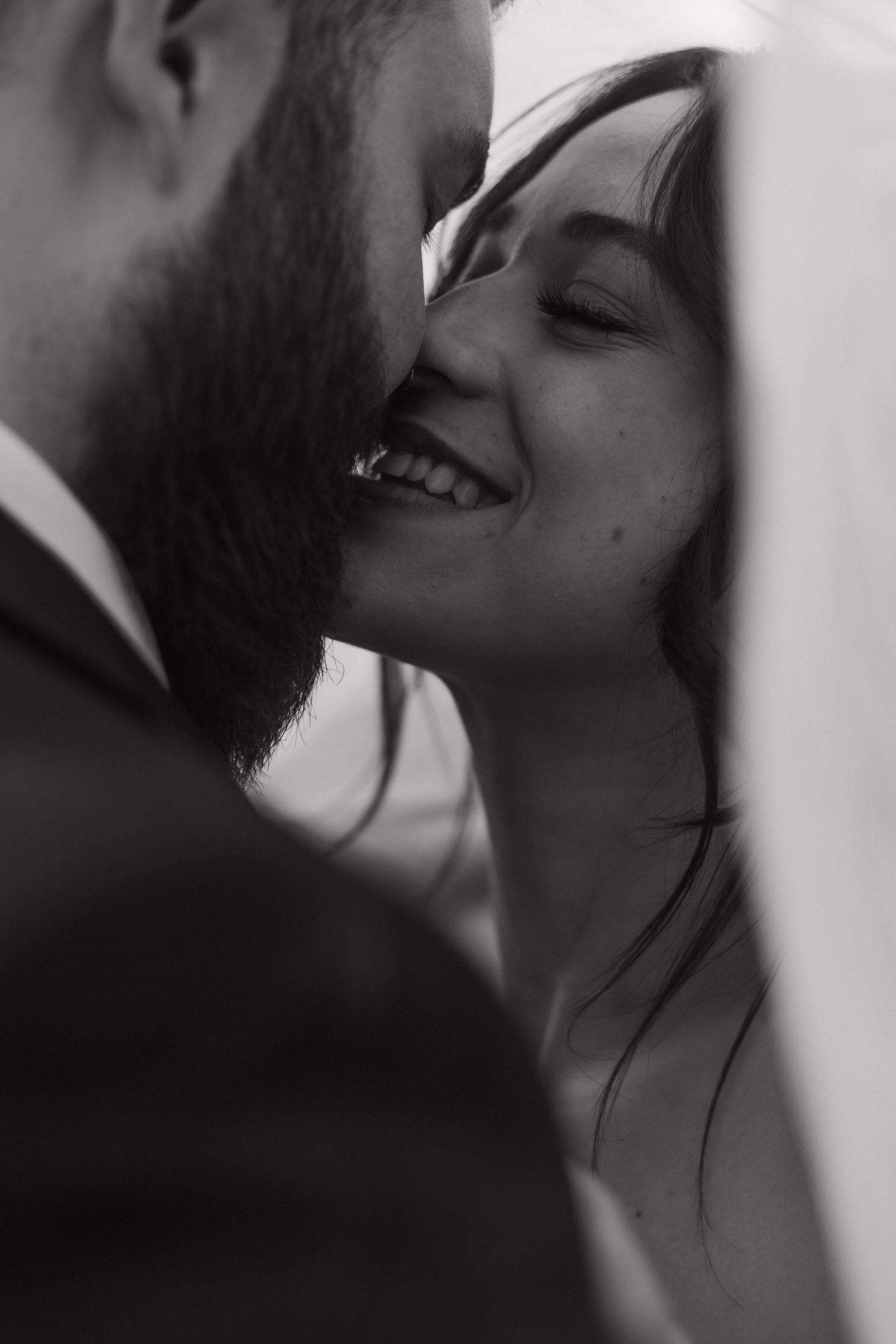 An intimate black and white moment between a couple sharing a tender moment.