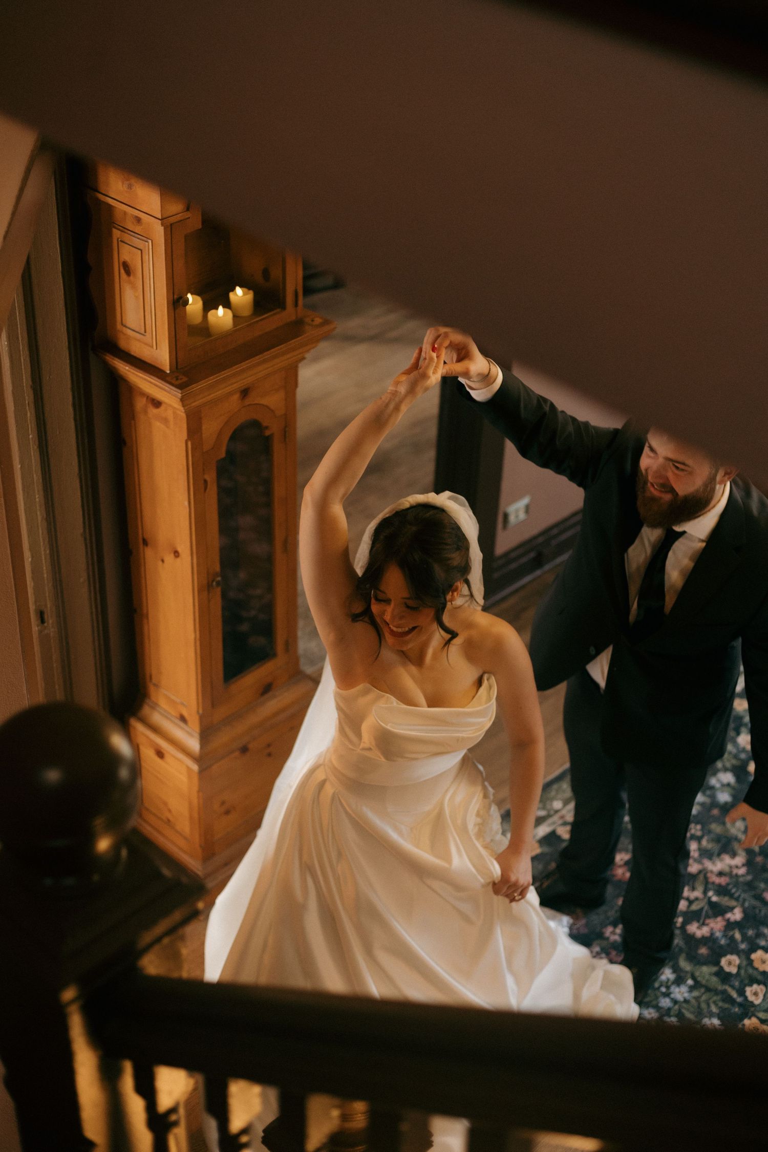 A couple dancing together in formal attire during an intimate indoor celebration.