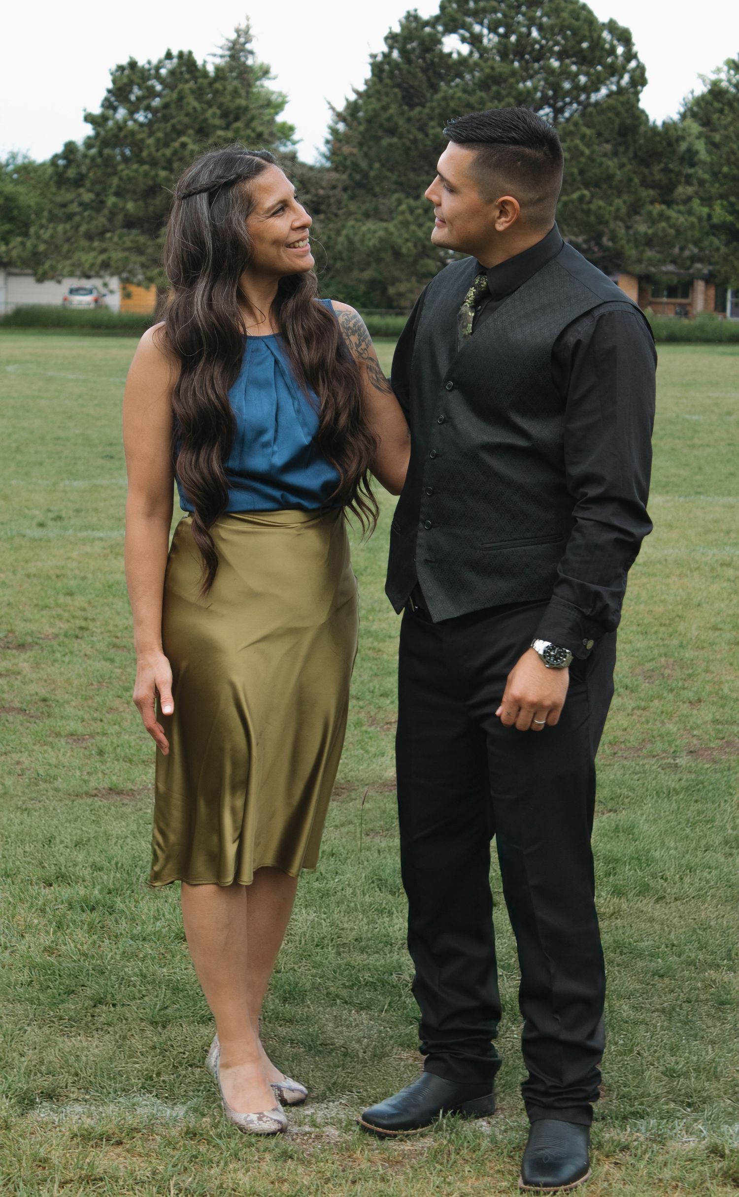Couple in formal wear sharing candid moments during outdoor photo session.